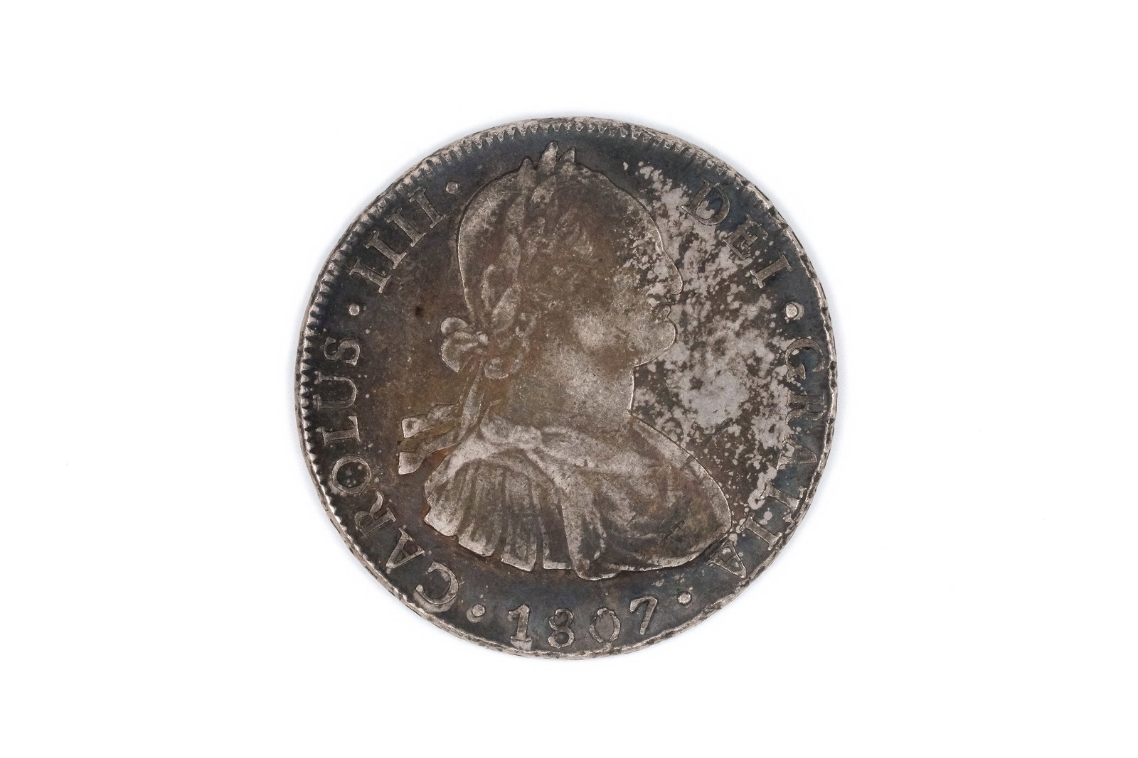 A Spanish silver 8 Reales coin of Charles IV, dated 1807: A Spanish silver 8 Reales coin of Charles IV, dated 1807. With draped bust of Charles IV on the obverse, and crowned arms between columns on the reverse. Weight: 27g