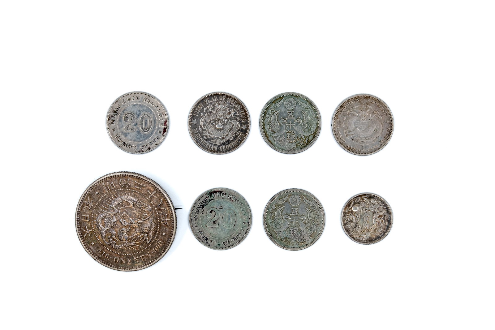 A lot of eight Asian silver coins, dated late 19th to early 20th century: A lot of eight Asian silver coins, comprising Chinese provincial issues and Japanese coins, dated late 19th to early 20th century. Including dragon type coins, phoenix and floral designs, and pieces w