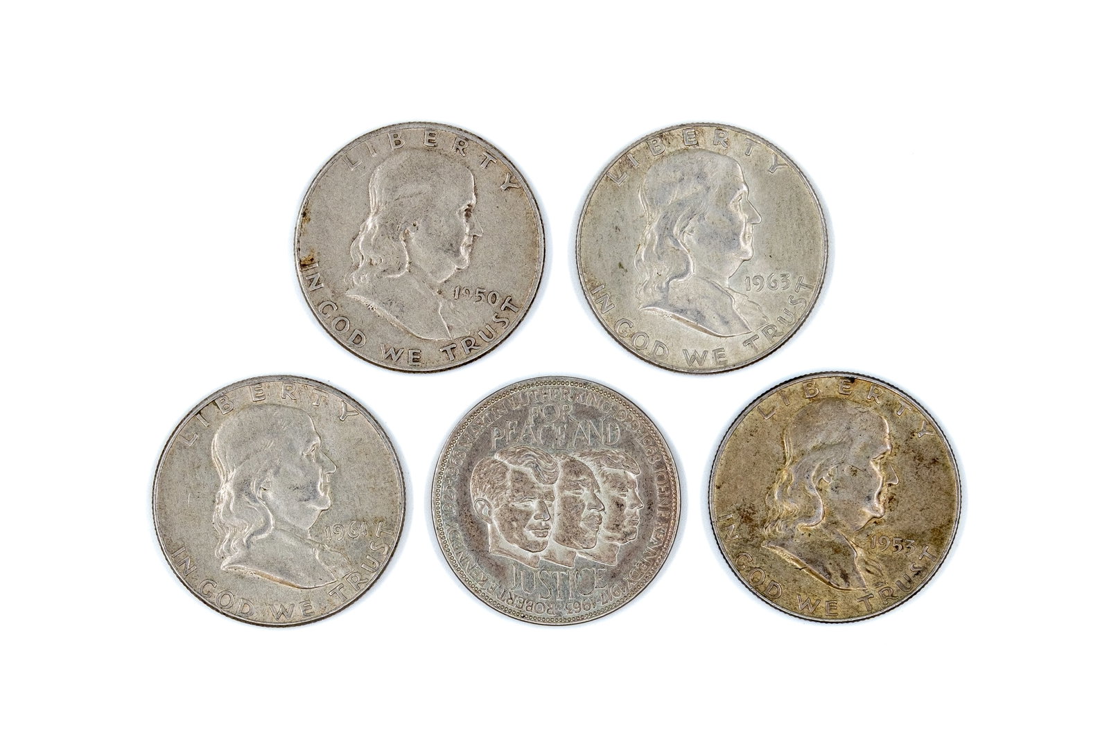 A lot of five United States silver half dollars, dated 1950-1963: A lot of five United States silver half dollars, dated 1950-1963. Comprising four Franklin half dollars depicting the portrait of Benjamin Franklin on the obverse and the Liberty Bell on the reverse, 