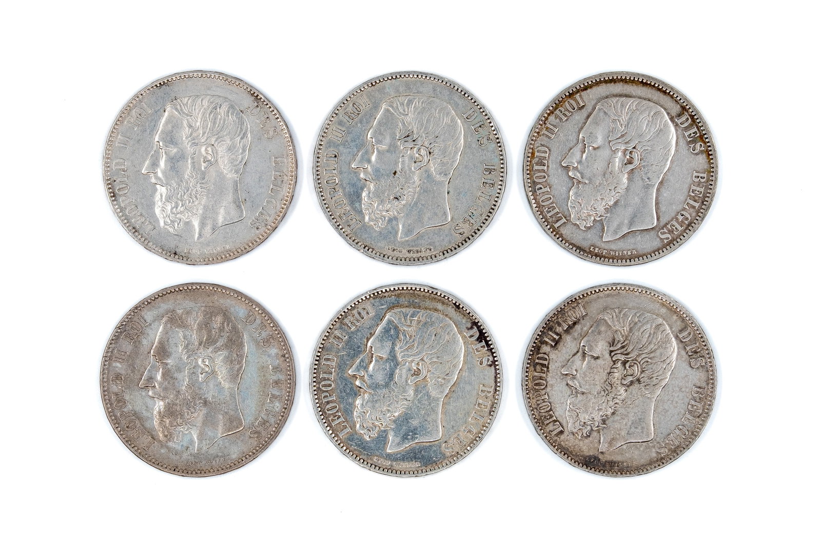 A lot of six Belgian silver 5 Francs coins of Leopold II, dated 1868-1874: A lot of six Belgian silver 5 Francs coins of Leopold II, dated 1868-1874. All issues of Leopold II, with crowned coat of arms within wreath reverse. Total weight: 149,6g