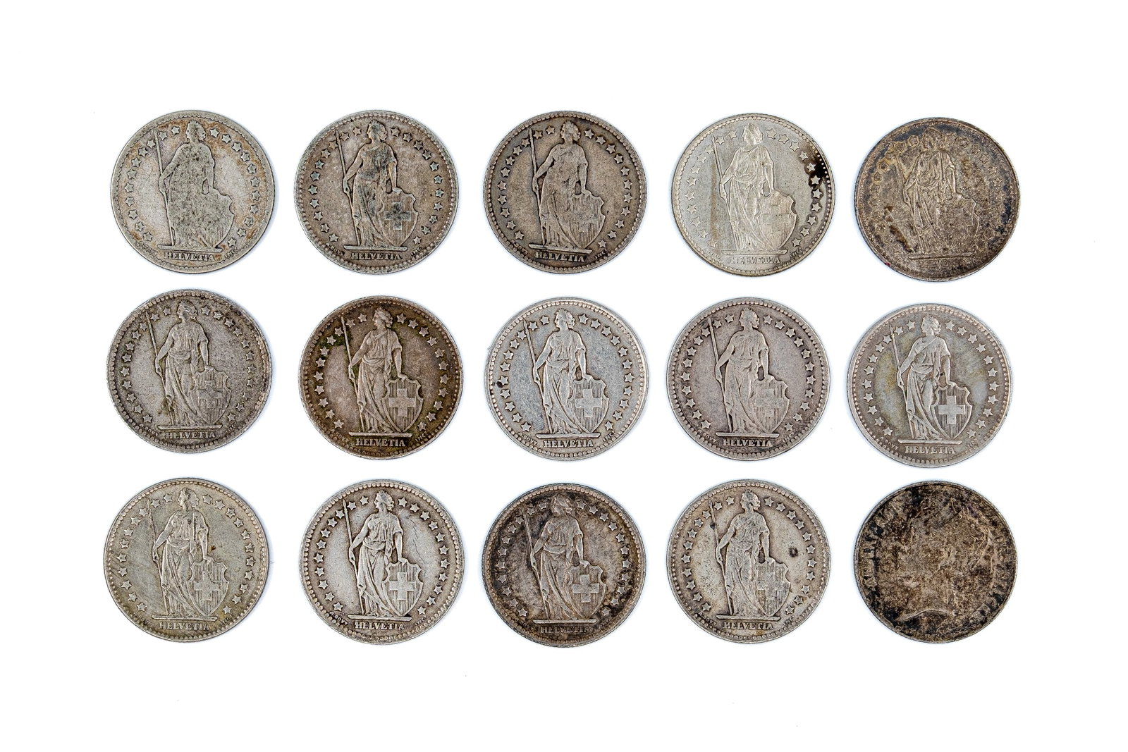 A lot of 15 Swiss 1 Franc coins, dated 1880-1963: A lot of 15 Swiss 1 Franc coins, dated 1880-1963. Comprising Helvetia standing type issues, with denominations within wreaths on the reverse. Total weight: 74,3g