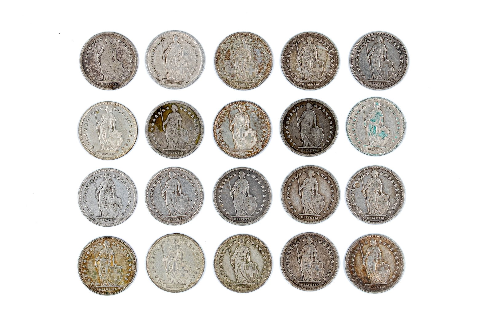 A lot of 20 Swiss silver 1 Franc coins, dated 1877-1964: A lot of 20 Swiss silver 1 Franc coins, dated 1877-1964. Comprising Helvetia standing type issues, with denominations within wreaths on the reverse. Total weight: 98,4g