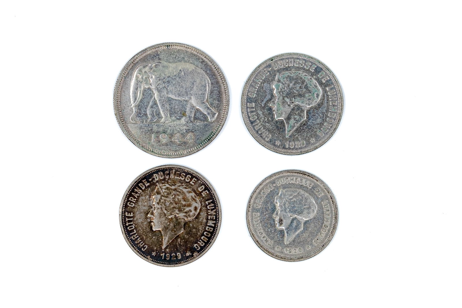 A lot of four silver coins from Luxembourg and the Belgian Congo, dated 1920-1944: A lot of four silver coins from Luxembourg and the Belgian Congo, dated 1920-1944. Comprising three Luxembourg issues of Grand Duchess Charlotte, including 5 Francs and 10 Francs types with crowned ar