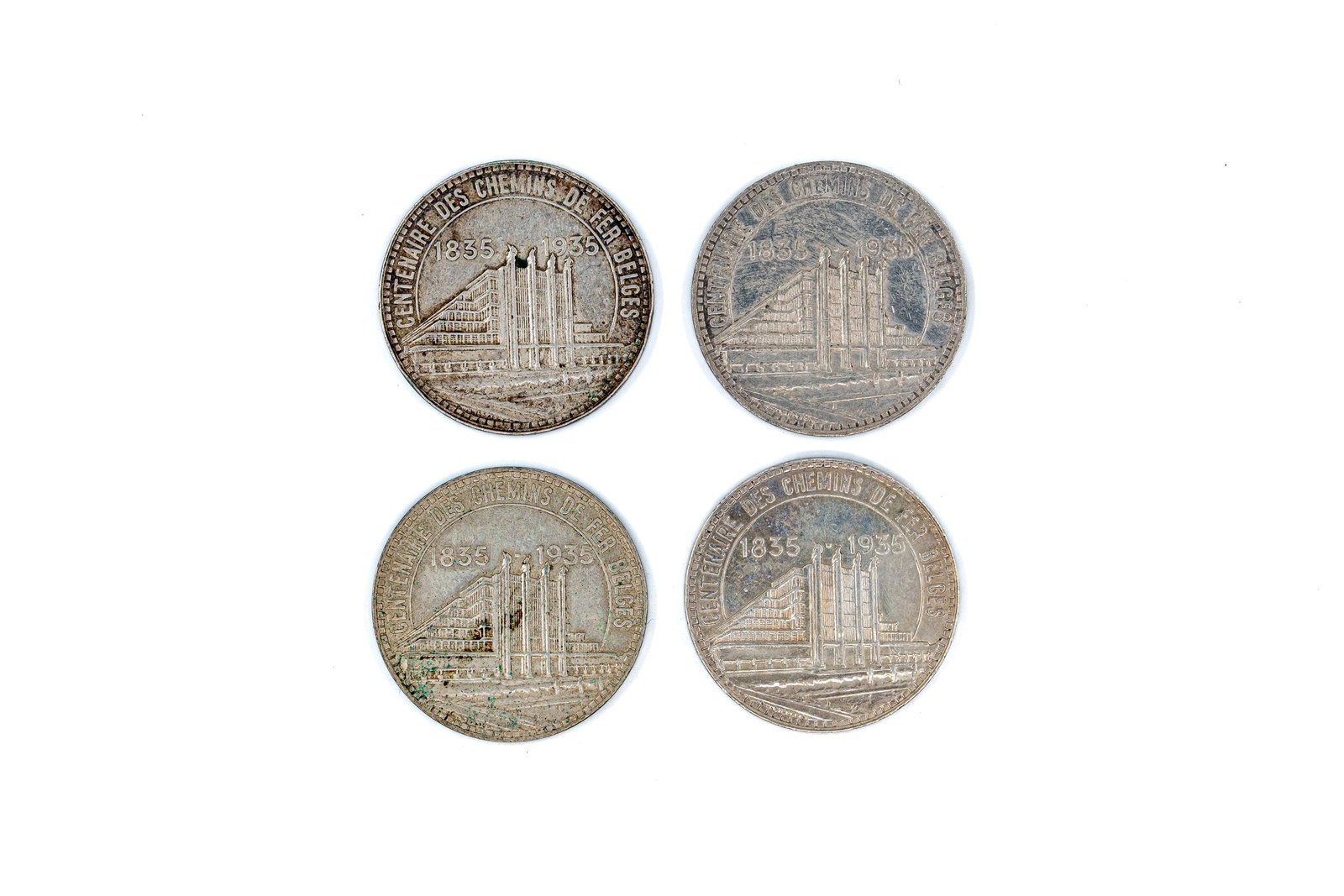 A lot of four Belgian silver 50 Francs commemorative coins, dated 1935: A lot of four Belgian silver 50 Francs commemorative coins, dated 1935. Comprising commemorative issues for the centenary of the Belgian railways and the Brussels International Exhibition, with archit
