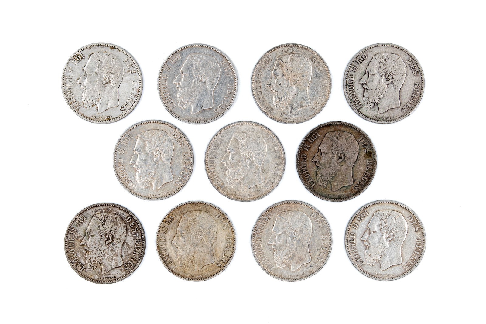 A lot of 11 Belgian silver 5 Francs coins of Leopold II, dated 1868-1876: A lot of 11 Belgian silver 5 Francs coins of Leopold II, dated 1868-1876. All Belgian silver issues with crowned shield reverse within wreath. Total weight: 273,5g