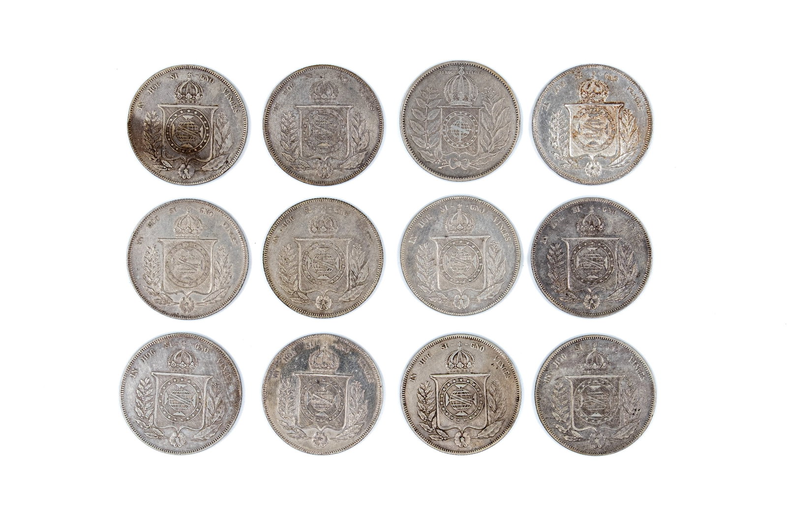A lot of 12 Brazilian silver 1000 Réis coins of Pedro II, dated 1852-1866: A lot of 12 Brazilian silver 1000 Réis coins of Pedro II, dated 1852-1866. Comprising all silver issues with imperial arms on one side and denomination within wreath on the other. Total weight: 152,1