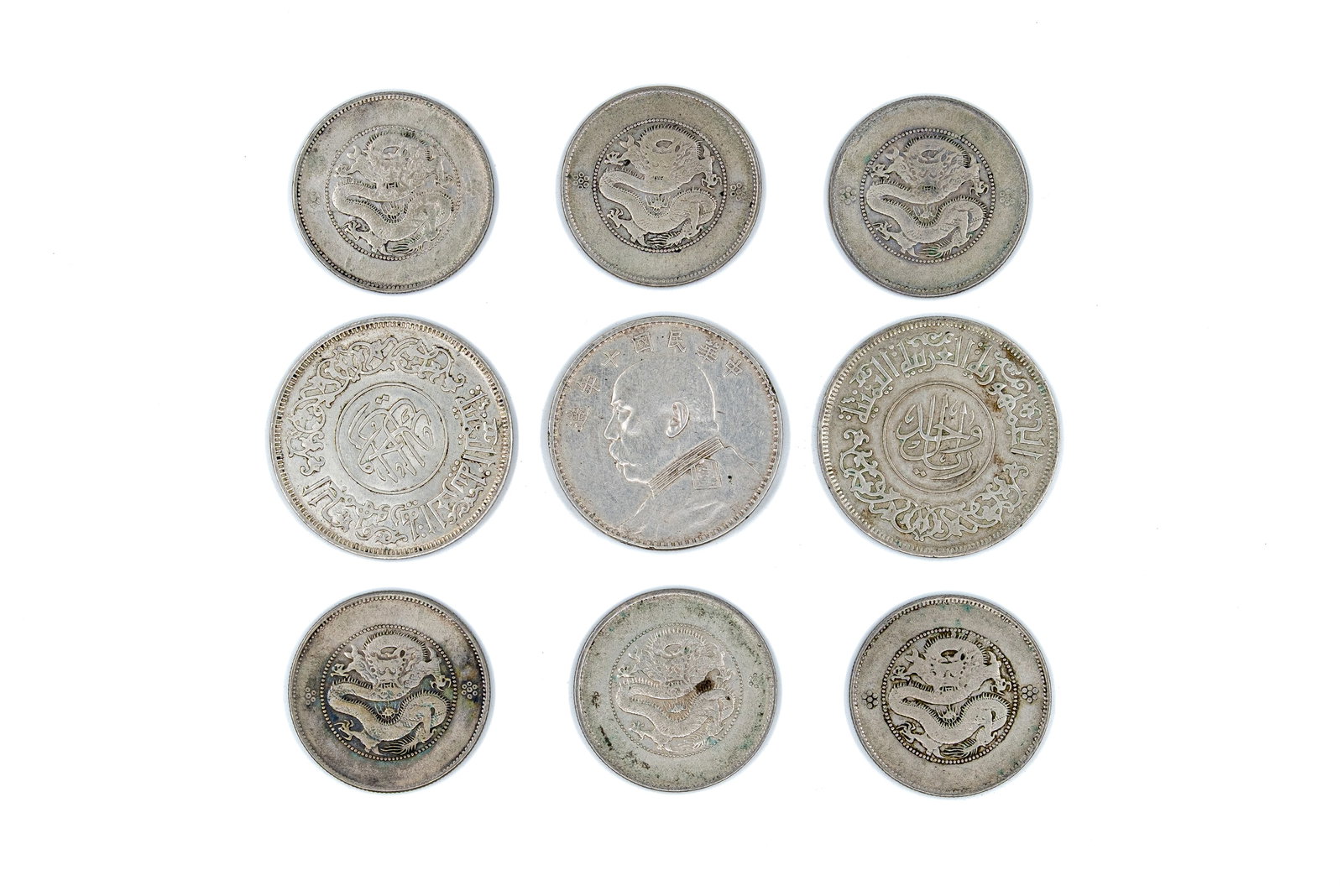 A lot of nine Asian silver coins, 20th century: A lot of nine Asian silver coins, 20th century. Comprising mixed issues with dragon, portrait and Arabic-script designs. Total weight: 146,7g