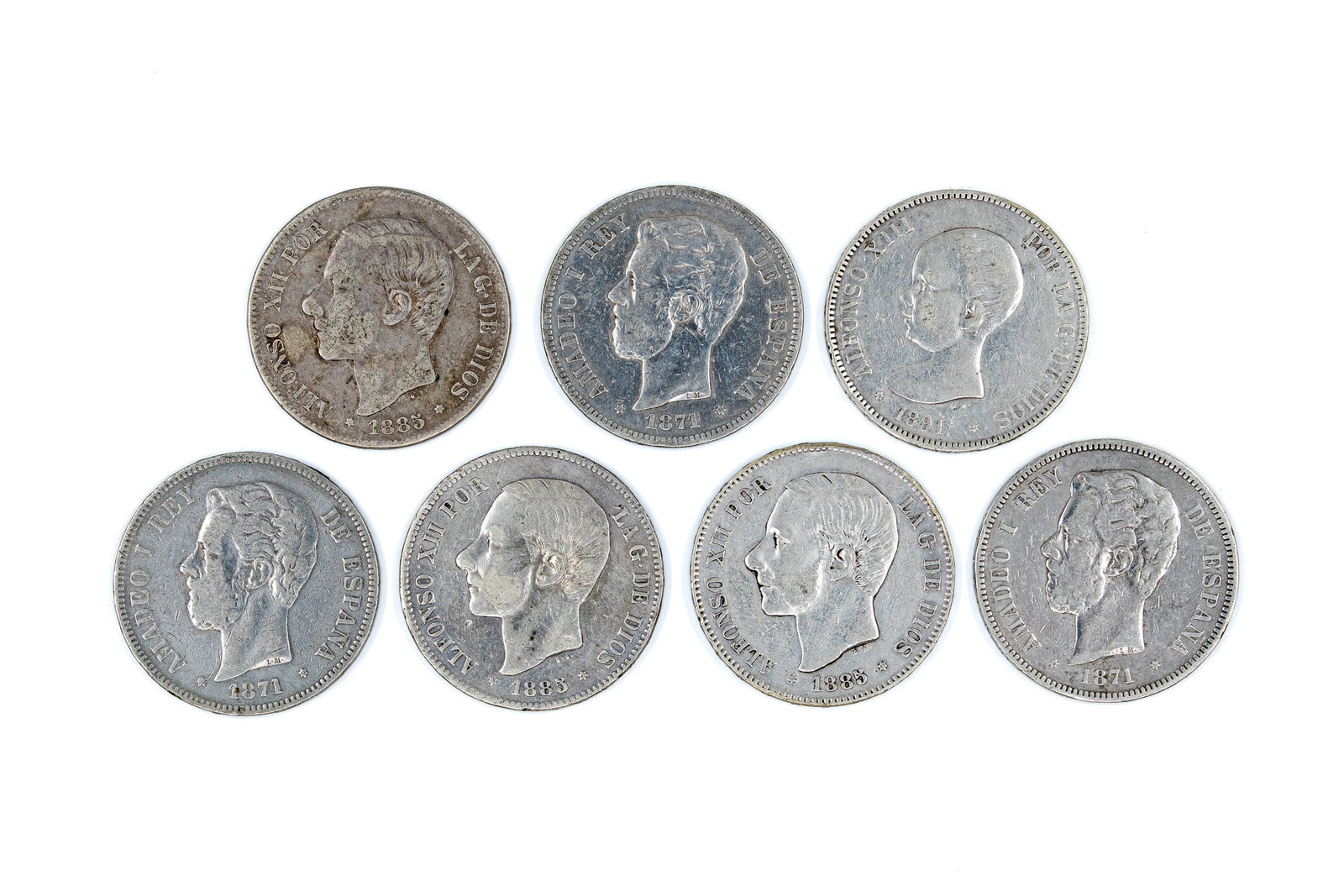 A lot of seven Spanish silver 5 Pesetas coins, dated 1871-1891: A lot of seven Spanish silver 5 Pesetas coins, dated 1871-1891. Comprising issues of Amadeo I, Alfonso XII and Alfonso XIII, with royal portraits on the obverse and crowned arms on the reverse. Total 