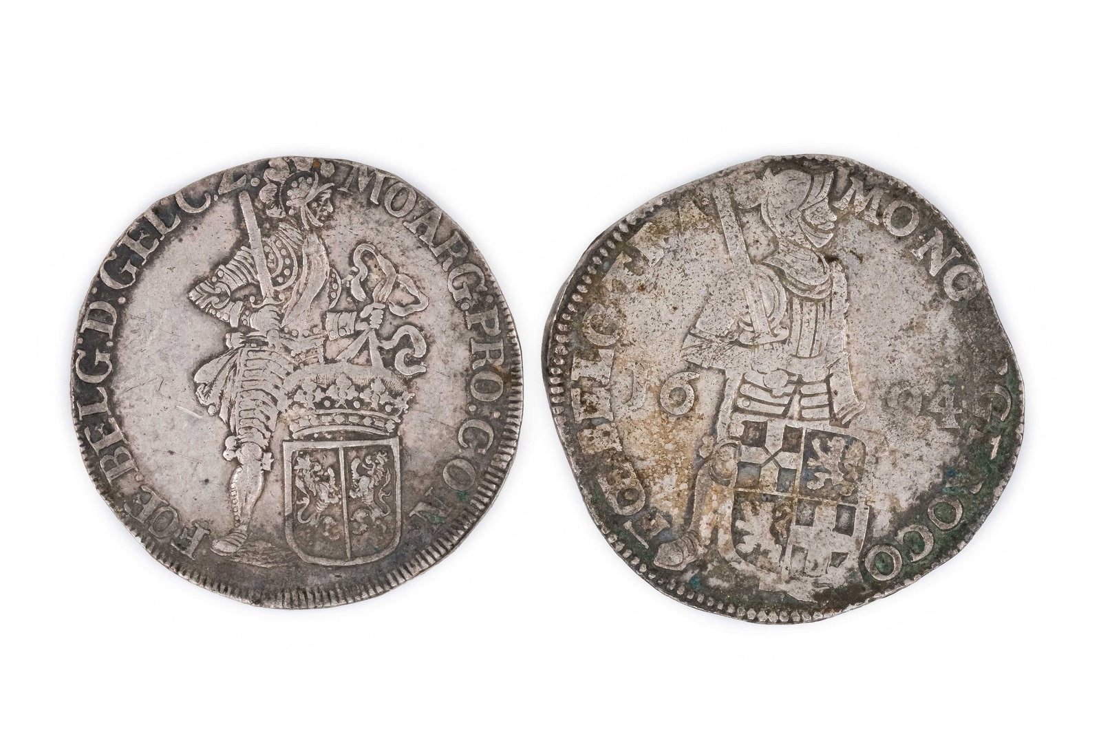 A lot of two silver coins of the Spanish Netherlands, dated 1694: A lot of two silver coins of the Spanish Netherlands, dated 1694. Comprising issues depicting standing armoured knight figures on the obverse and crowned shield and lion on the reverse. Weight: 27,7 -
