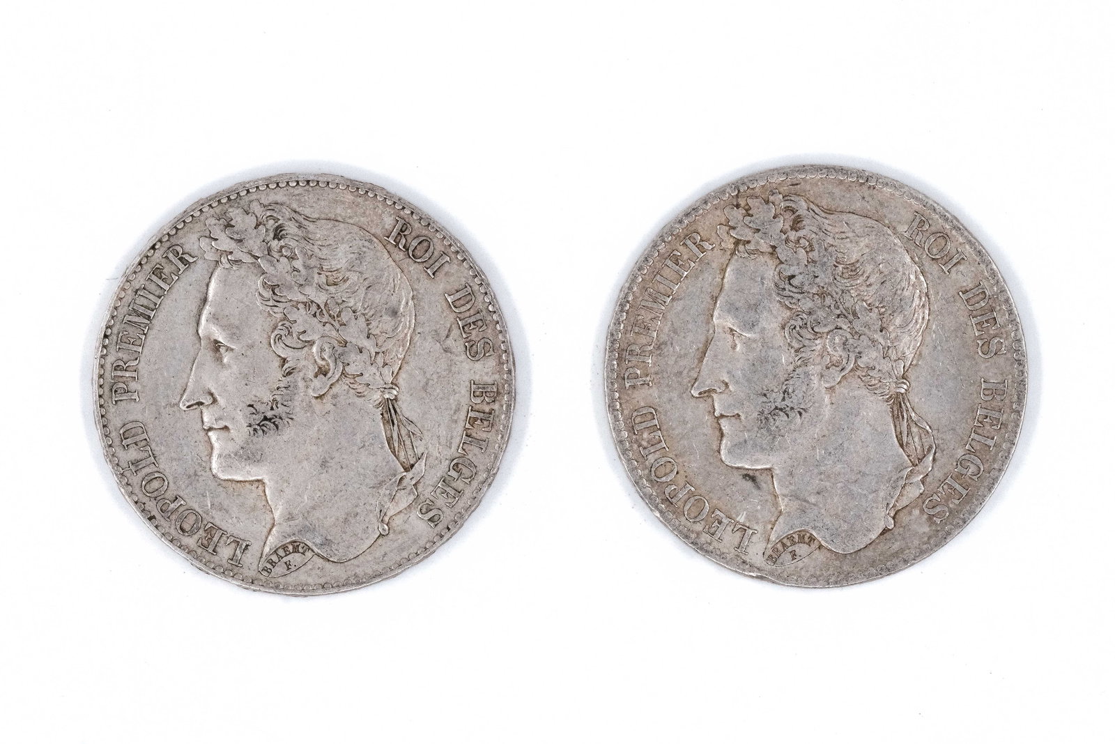A lot of two Belgian silver 5 Francs coins of Leopold I, dated 1833 and 1849: A lot of two Belgian silver 5 Francs coins of Leopold I, dated 1833 and 1849. Comprising laureate head facing left, the reverse depicting denomination within wreath. Weight: 24,9 - 24,9g