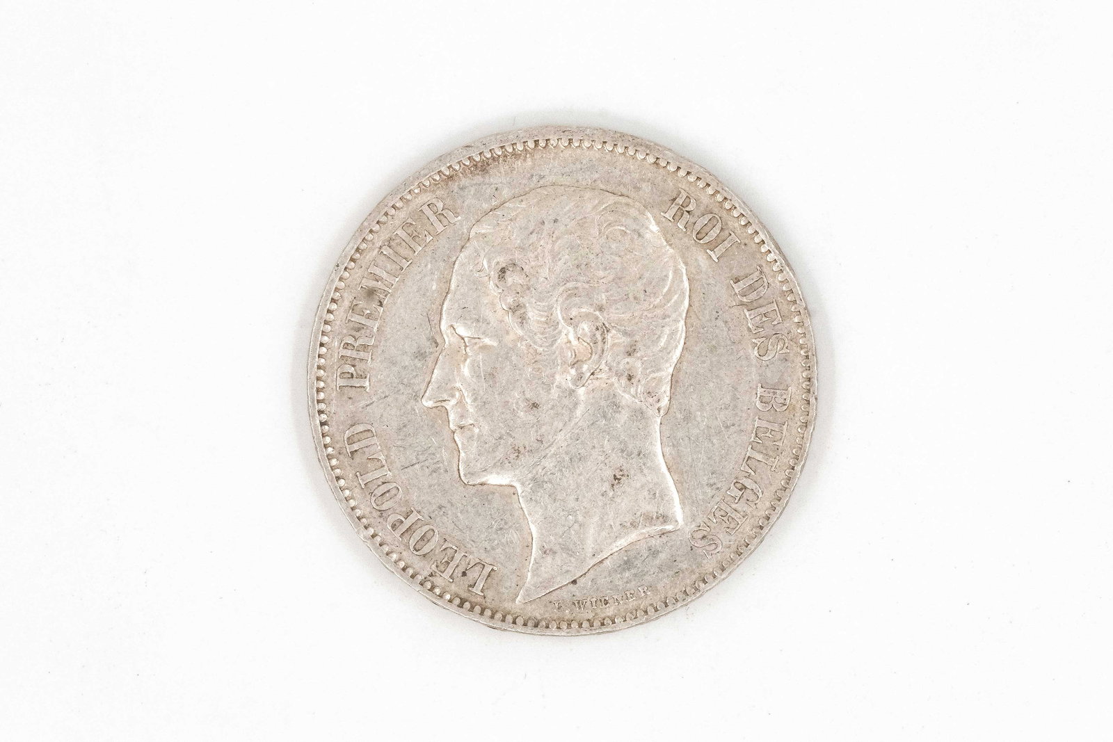 A silver 5 Francs of Leopold I, dated 1858: A silver 5 Francs of Leopold I, dated 1858. Observe with bare head facing left, the reverse depicting crowned coat of arms within wreath and legend. Weight: 25,1g