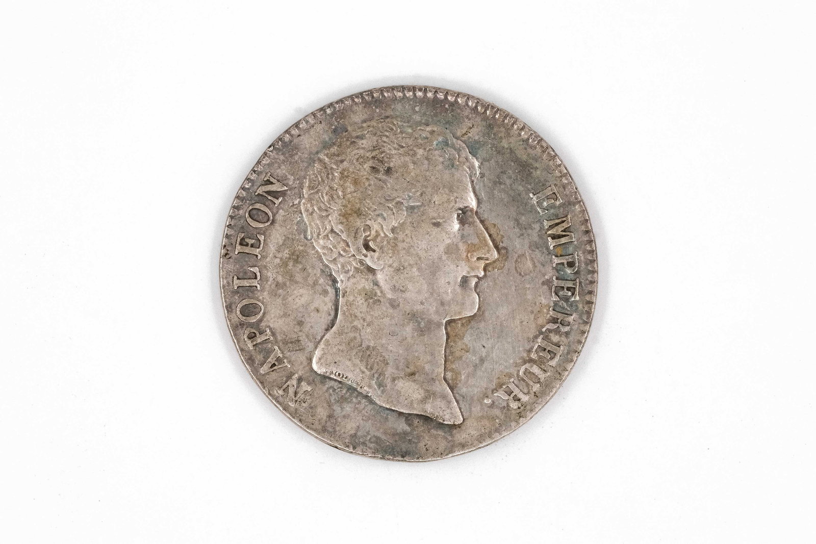 A French silver 5 Francs coin, dated AN 12 (1804): A French silver 5 Francs coin, dated AN 12 (1804). With bare head of Napoleon I facing right and surrounding legend, the reverse with denomination within wreath and inscription. Weight: 25,1g