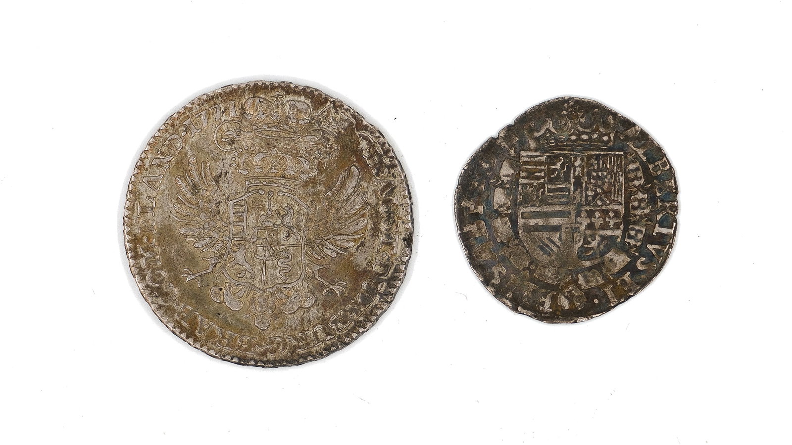 A lot of two silver coins, dated 1771 and illegible: A lot of two silver coins, dated 1771 and illegible. Comprising a larger Austrian issue with crowned double-headed eagle and a smaller hammered-type coin with cross motif on the reverse. Weight: 14,7 