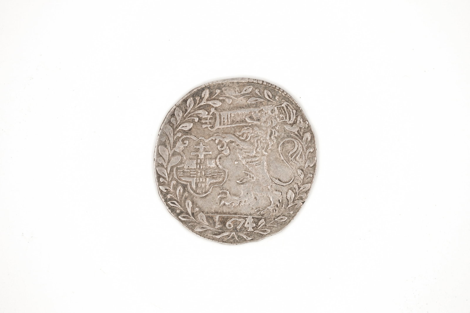 A Dutch Republic silver 1 Gulden coin, dated 1674: A Dutch Republic silver 1 Gulden coin, dated 1674. With crowned shield within wreath on the obverse, and a lion holding a sword and bundle of arrows within wreath on the reverse. Weight: 6,3g