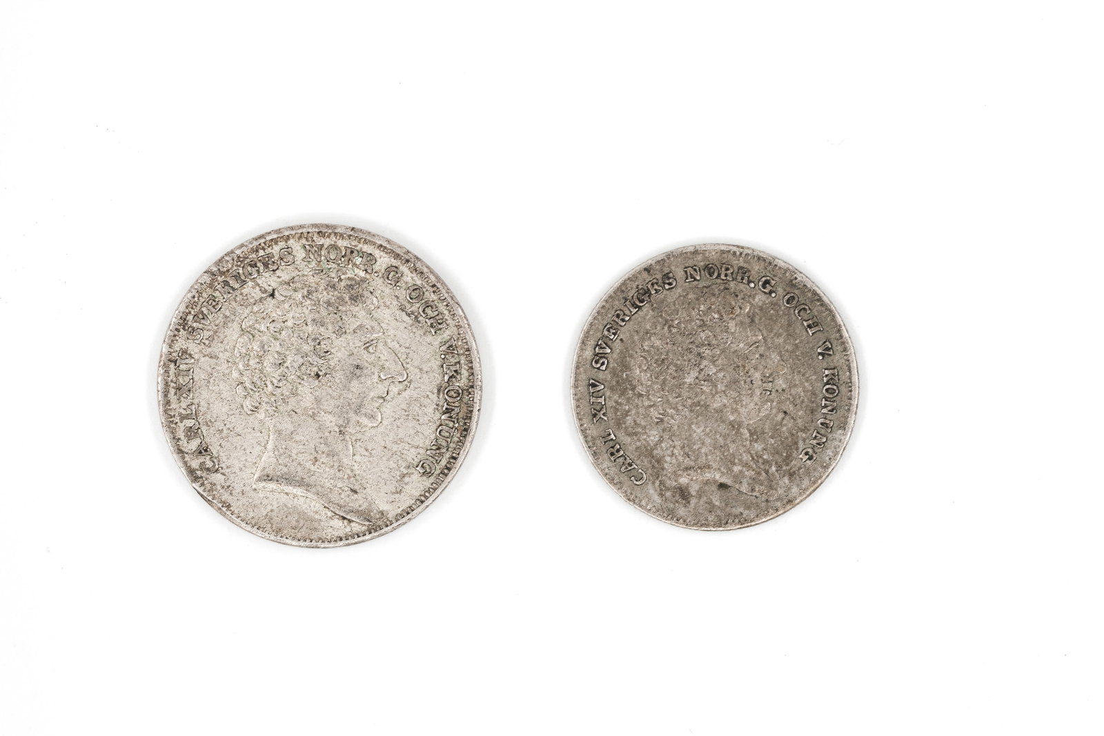 A lot of two Swedish silver coins of Karl XIV Johan: A lot of two Swedish silver coins of Karl XIV Johan, comprising a 1/4 Riksdaler and a 1/8 Riksdaler, dated 1832 and 1834. With laureate head on the obverse and crowned shield on the reverse. Weight: 8