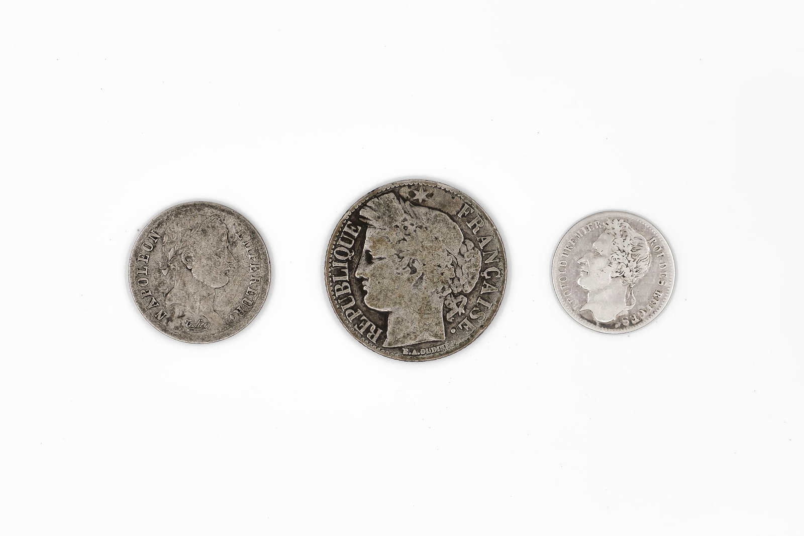 A lot of three silver coins, comprising two French issues and one Belgian coin, dated 1808-1888: A lot of three silver coins, comprising two French issues and one Belgian coin, dated 1808-1888. Including a French 1 Franc and 1/2 Franc, and a Belgian 1/4 Franc, with portraits on the obverse and de