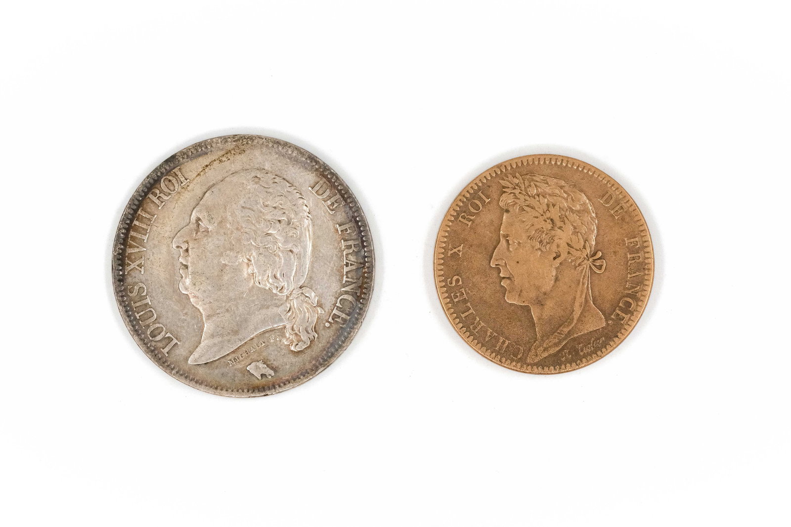 A lot of two French coins dated 1822 and 1827: A lot of two French coins, comprising a silver 5 Francs piece of Louis XVIII and a copper 10 Centimes coin of Charles X, dated 1822 and 1827. Including a silver issue with laureate head of Louis XVIII