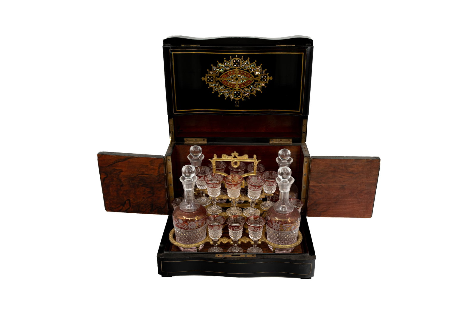 An antique Napoleon III blackened wooden Tantalus liquor finely decorated cabinet: An antique Napoleon III blackened wooden Tantalus liquor cabinet, finely decorated with burl wood veneer and marquetry inlay with abalone shell, containing four red and clear cut crystal decanters and