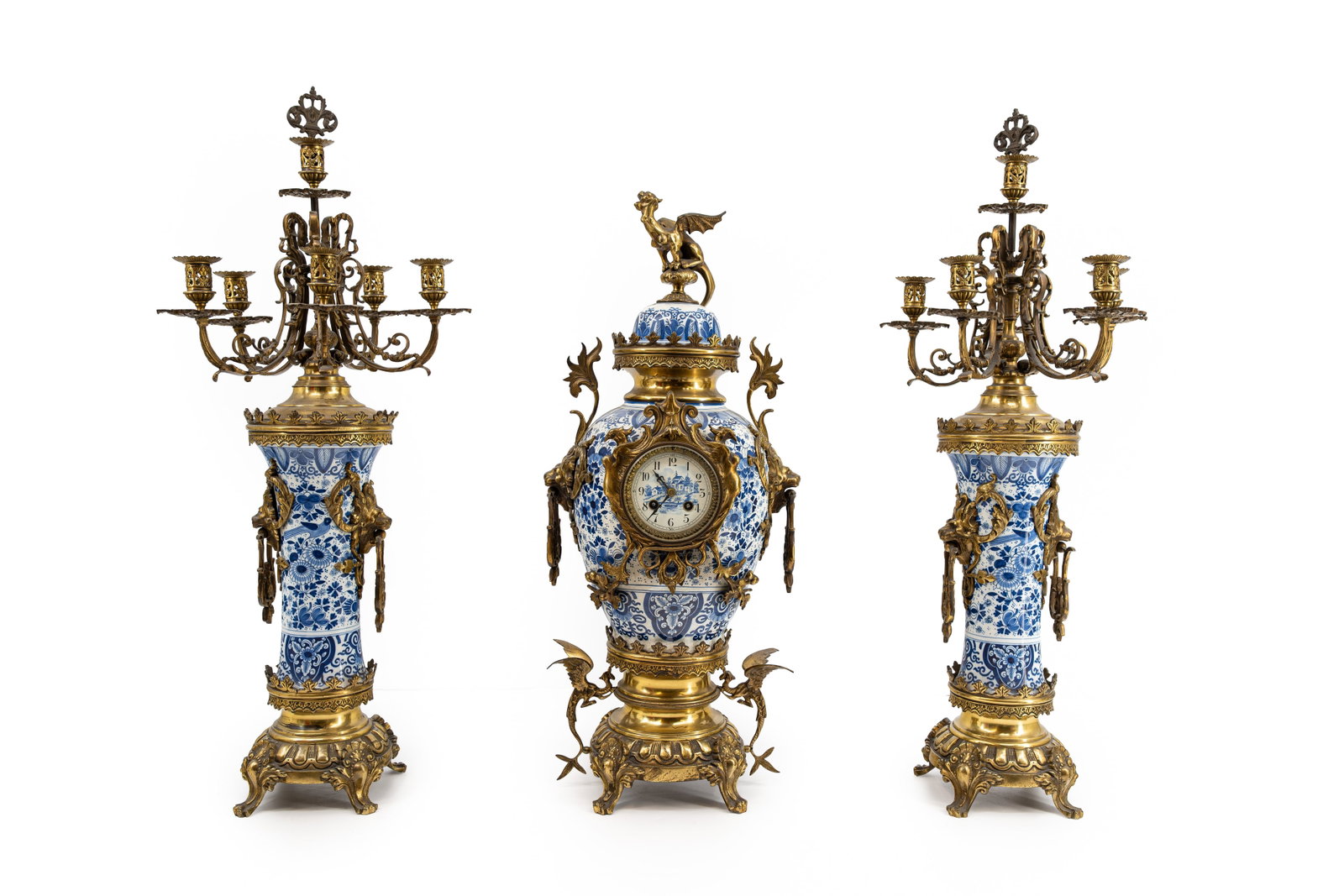 An imposing Delfts style and brass mantel clock with matching candelabras: An imposing mantel clock with matching candelabras in dutch Delfts style decorated ceramic and polished brass mountings. Circa 1900. H: 71 - W: 30 cm, clock