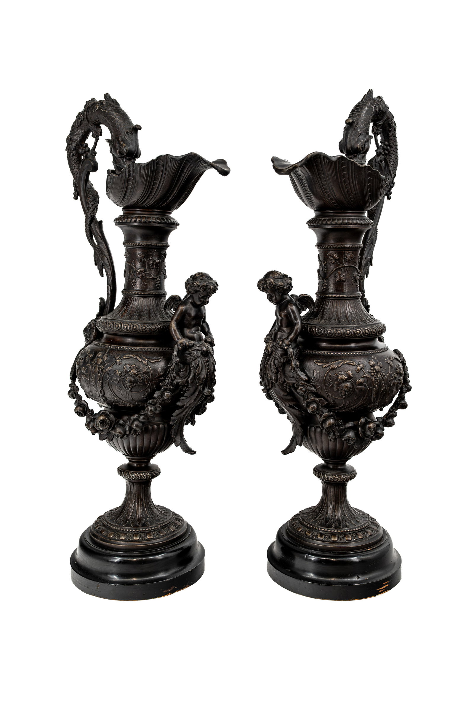 A lot of two large Rococo-style patinated spelter ewer vases: A lot of two large Rococo-style patinated spelter ewer vases, each with a handle and mounted on a wooden base. Circa 1900. H: 64 cm.