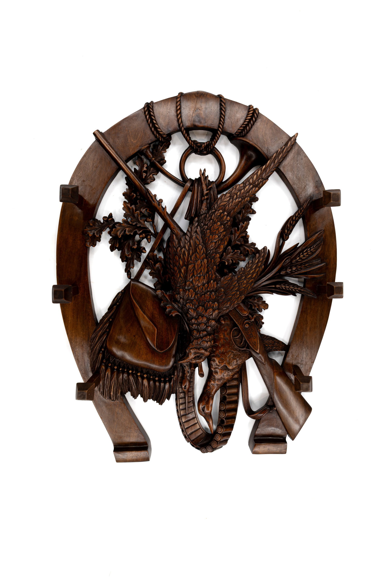 An antique German Black forest carved wooden horseshoe-shaped wall ornament: An antique German Black forest carved wooden horseshoe-shaped wall ornament decorated with hunting trophies. 19th/20th century. H: 90 - W: 70 cm
