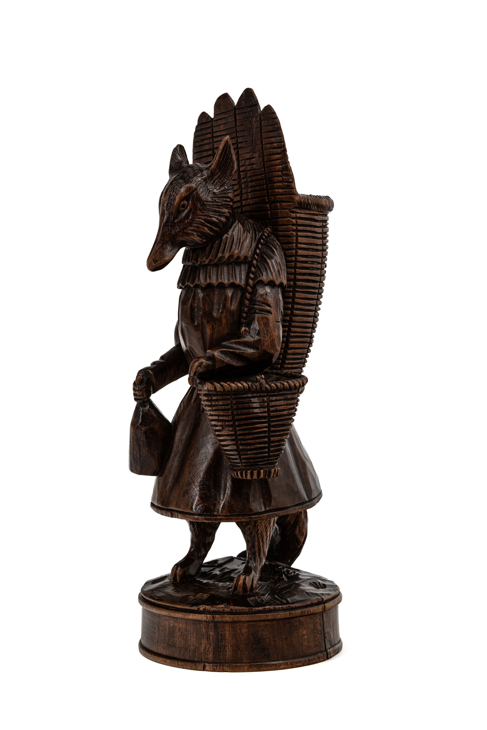 An antique German Black Forest carved wood figural sculpture of a dressed fox as a grape-farmer: An antique German Black Forest carved wood figural sculpture of a dressed fox as a grape-farmer holding a bottle. 19th/20th century. Condition: small damage to the handle of the basket, report availab
