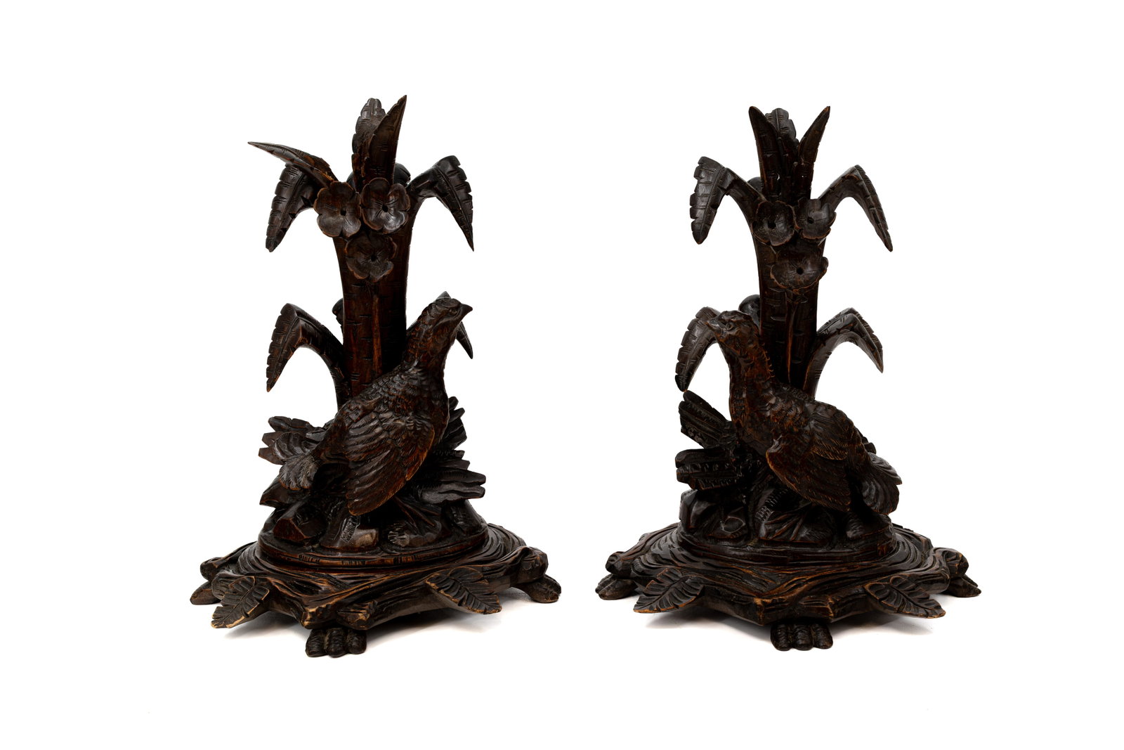 A pair of antique German Black forest carved wooden candlesticks: A pair of antique German Black forest carved wooden candlesticks decorated with birds. 19th/20th century. One leaf shows some damage, a condition report is available upon request. H: 30 cm