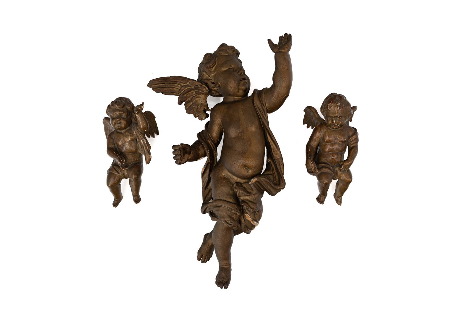 A lot of three antique patinated carved wood wall sculptures of winged cherubs: A lot of three antique patinated carved wood wall sculptures of winged cherubs. 18th/19th century. Condition: largest figure has damage to the wings. Report available on request. H: 22 - 50 - 24 cm