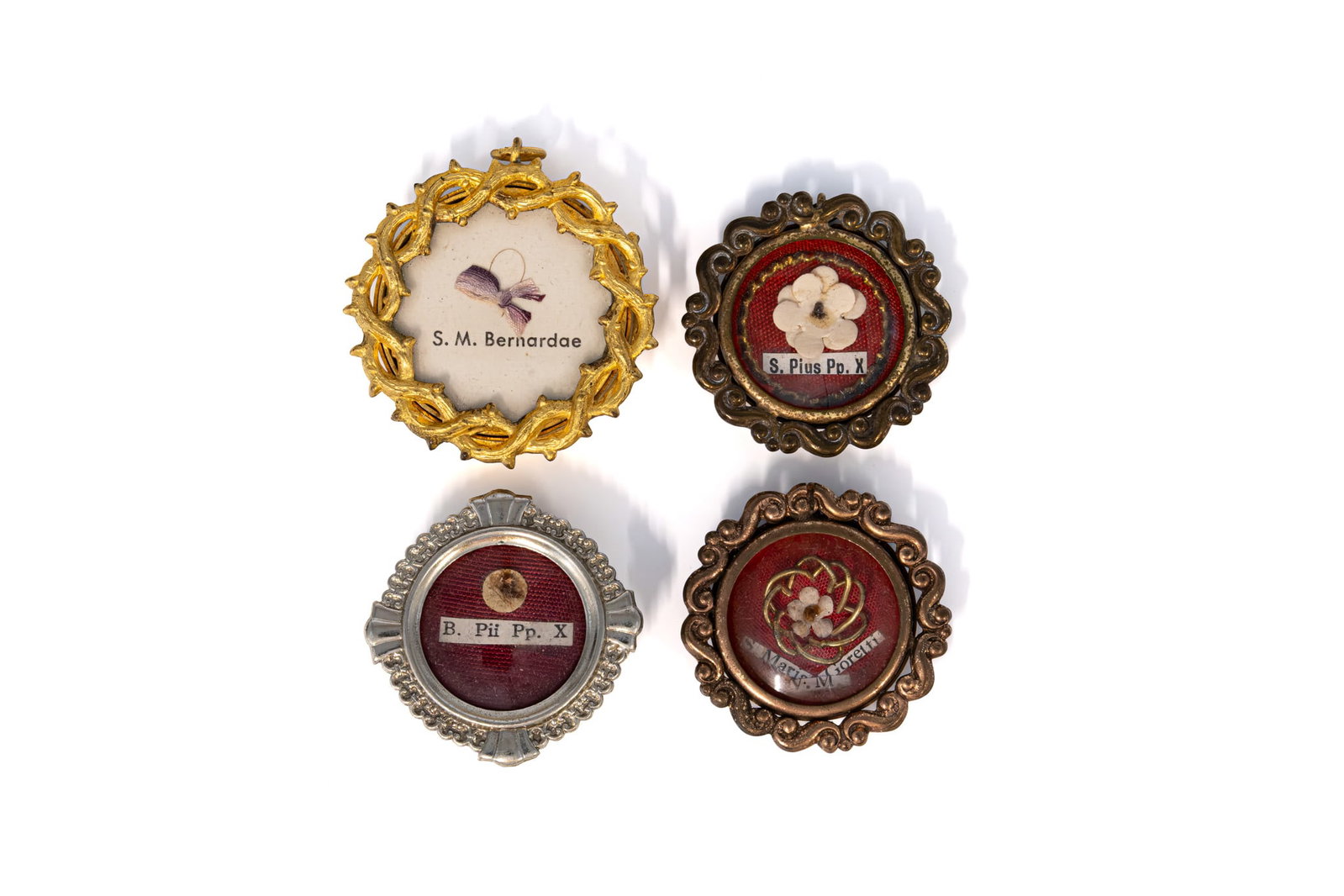 A composed lot of four sealed thecas containing relics of Saint Bernadette, Pope Saint Pius X and: A composed lot of four sealed thecas containing relics of Saint Bernadette, Pope Saint Pius X and Saint Maria Goretti, Virgin and Martyr. "S. M. Bernardae", "S. Pius Pp. X", "B. Pii Pp. X" and "S. Mar