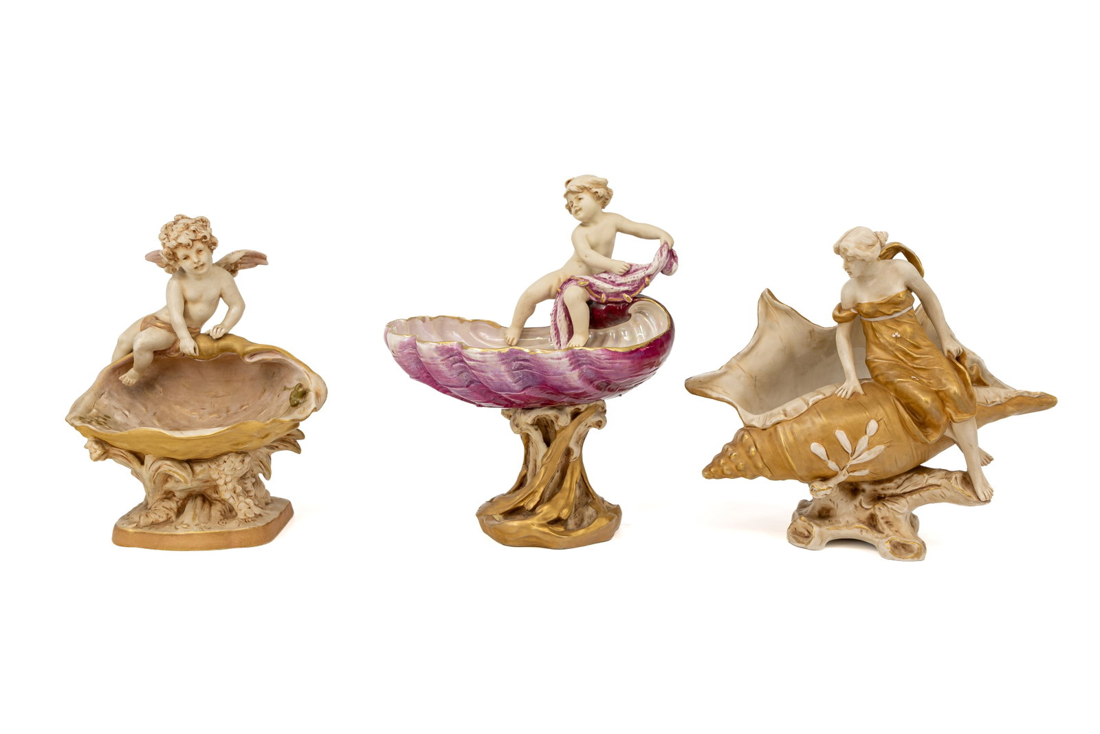 A composed lot of three Art Nouveau Bohemian Royal Dux figural centerpieces: A composed lot of three Art Nouveau Bohemian Royal Dux figural centerpieces, decorated with putti and a lady on a shell. Marked and first half of the 20th Century. H: 27 - 32 - 27,5 cm.