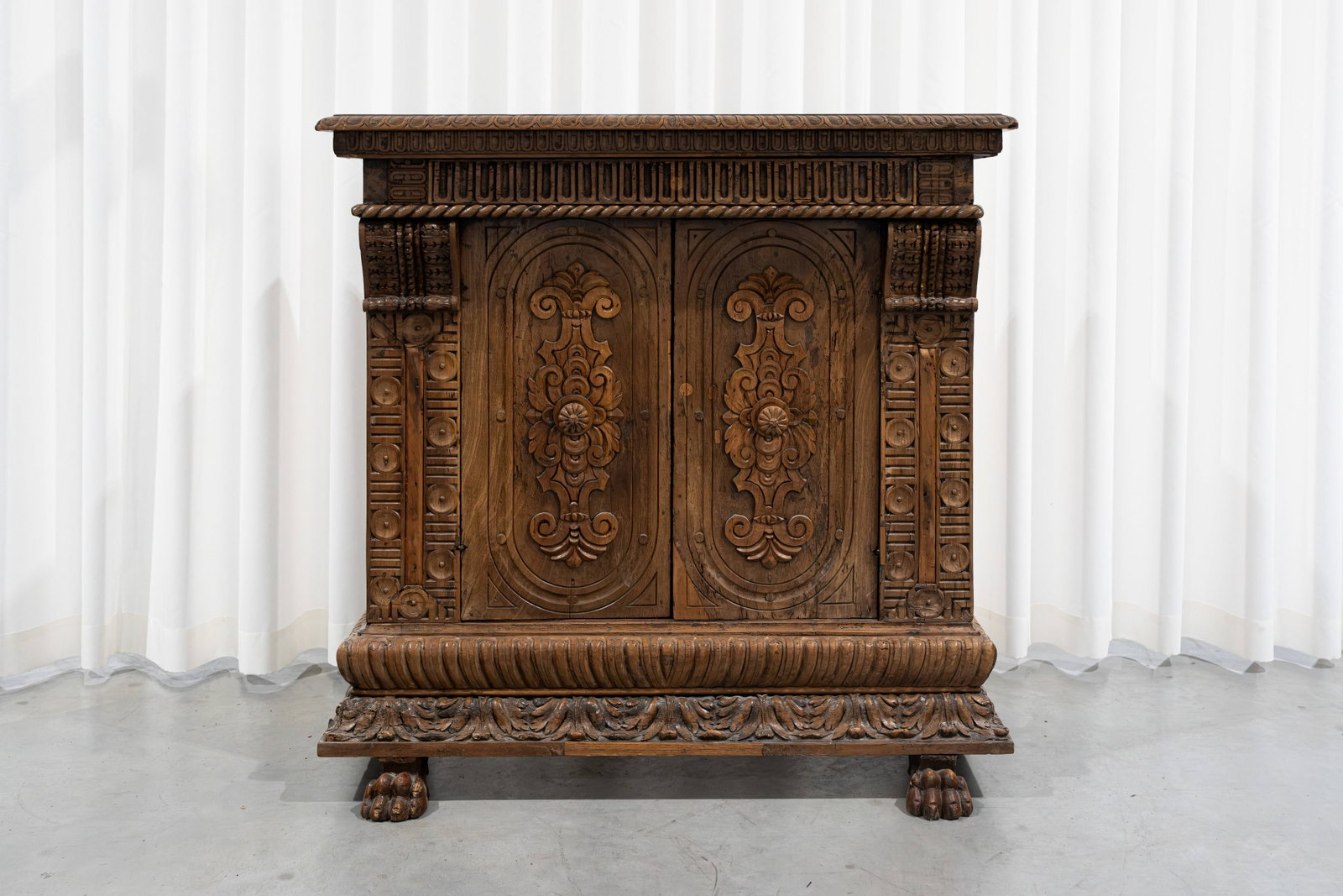 An antique and small renaissance style decorated two doors cabinet with claw shaped feet: An antique and small renaissance style decorated two doors cabinet with claw shaped feet. 18th century. H: 106 - W: 105 cm