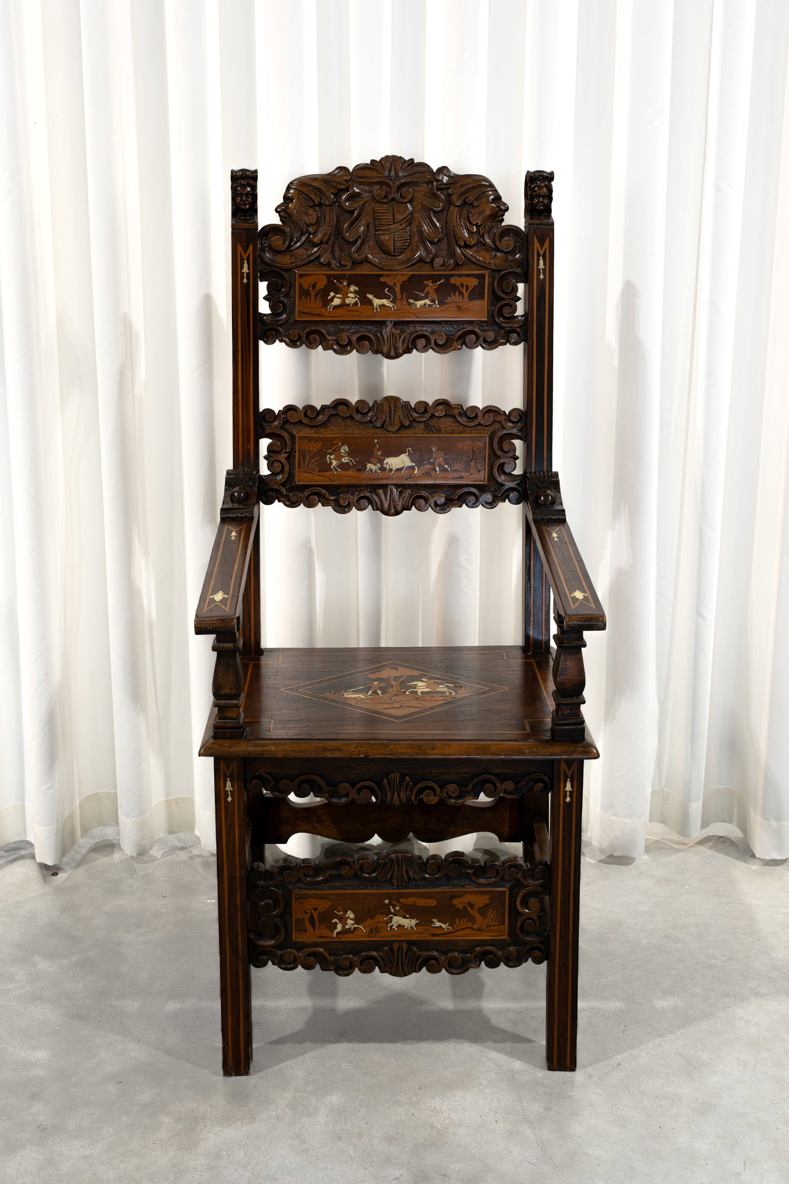 An antique Italian richly decorated carved walnut wooden armchair: An antique Italian richly decorated carved walnut wooden armchair with bone and marquetry inlay. 19th century. H: 137 - W: 56 - D: 56 cm