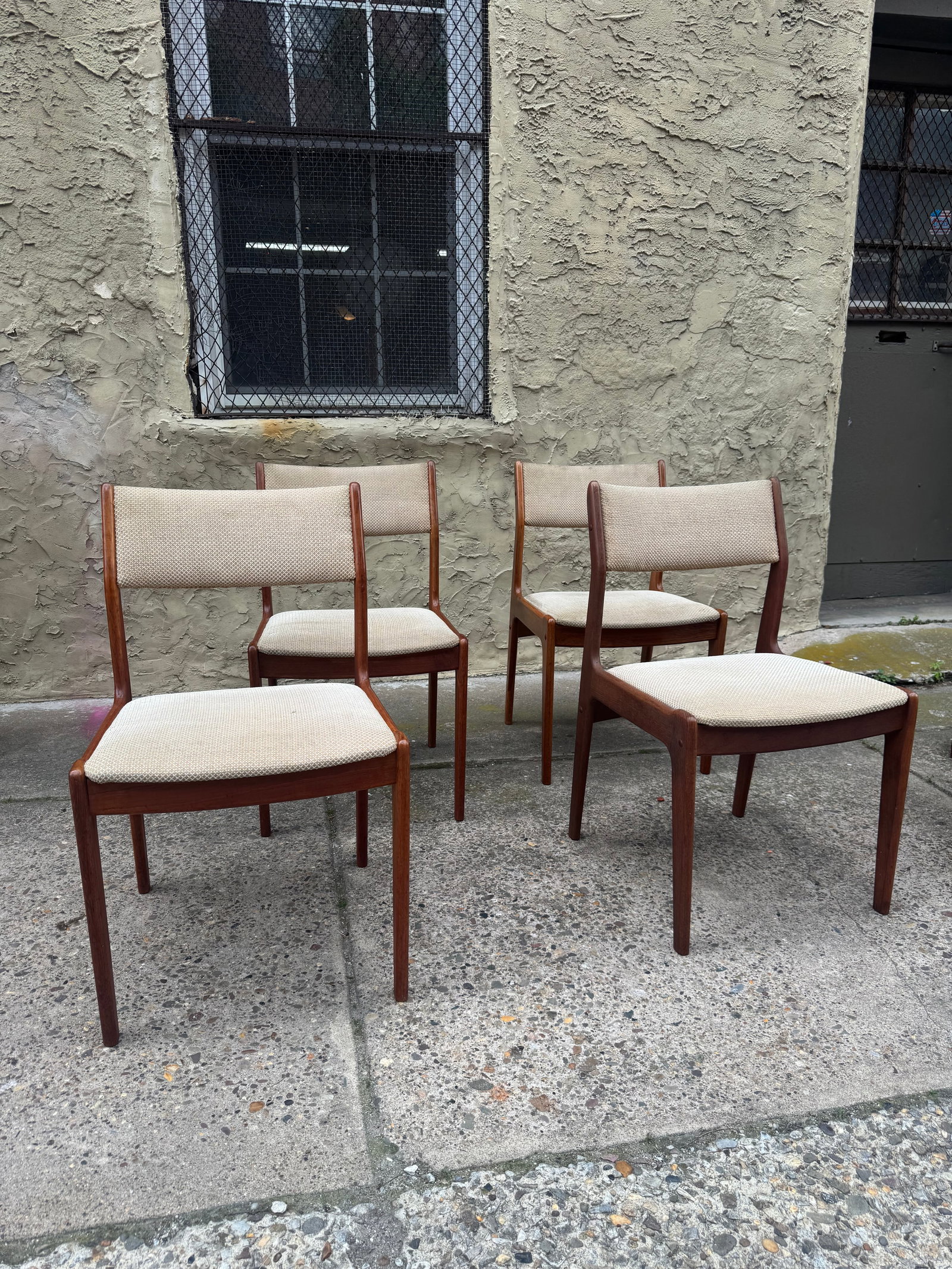 Set of Four Mid Century Modern Teak Dining Chairs, Danish Modern Style: Set of four mid-century modern dining chairs in solid teak, showcasing classic Scandinavian design with sculpted curved backrests and tapered legs. Upholstered in neutral oatmeal tweed with padded sea