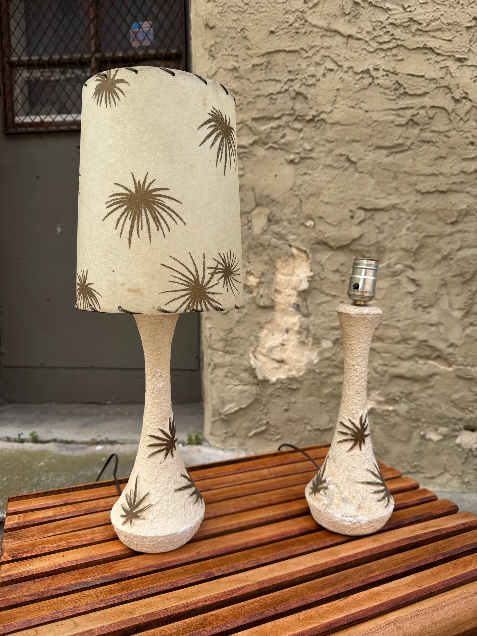 Pair of 1950s Atomic Chalkware Table Lamps by Plasto Manufacturing Co., Starburst Design: Stylish pair of vintage 1950s mid-century modern chalkware table lamps by Plasto Manufacturing Company, featuring textured white atomic-era bases with bold starburst motif detailing. Each lamp is topp