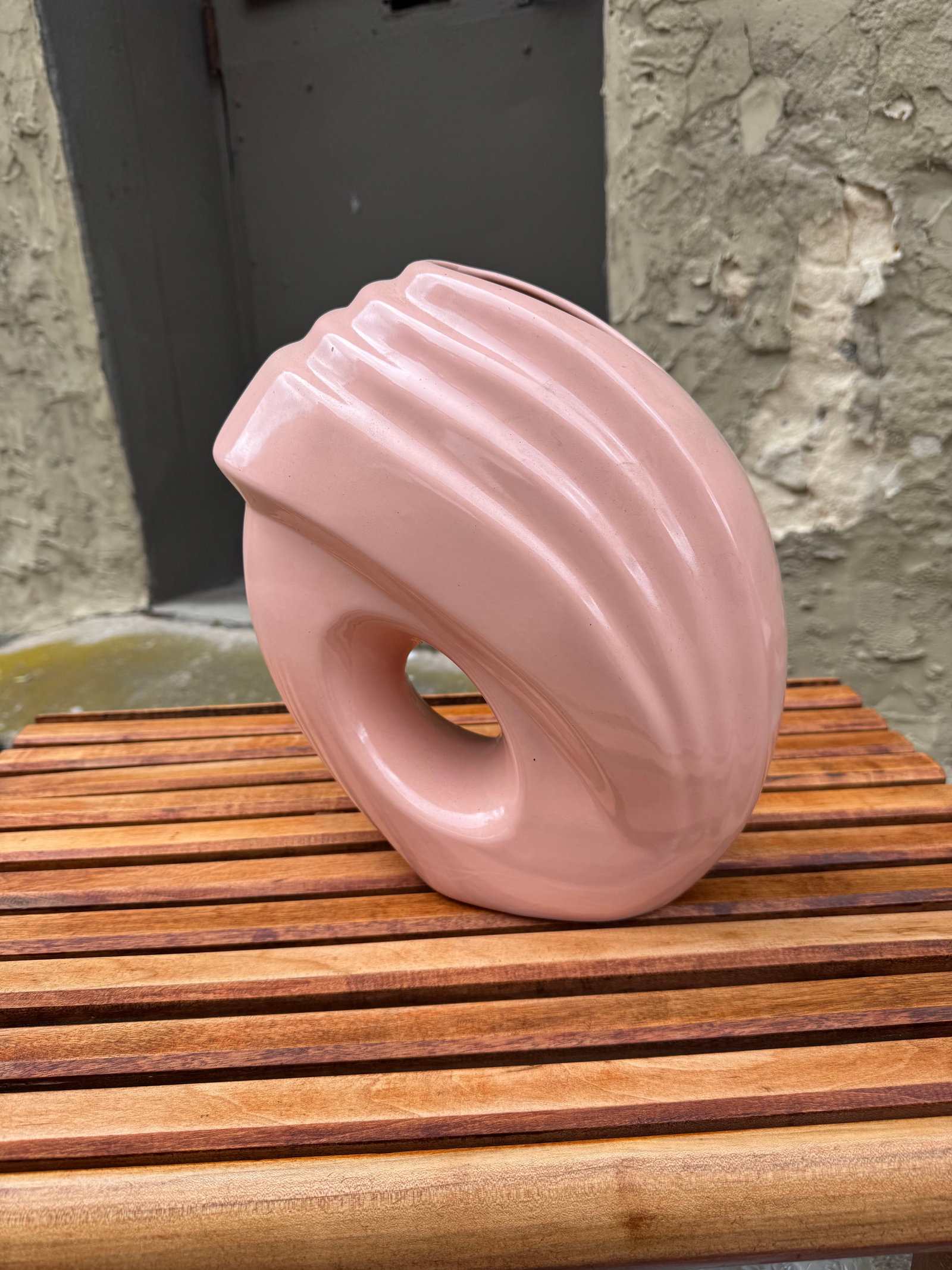 1980s Art Deco Revival Pink Ceramic Ribbon Vase: Striking 1980s postmodern ceramic vase featuring a glossy pastel pink glaze, sculptural ribbon-like ribbed form, and dramatic open center cutout. Its bold geometric silhouette captures the playful ele