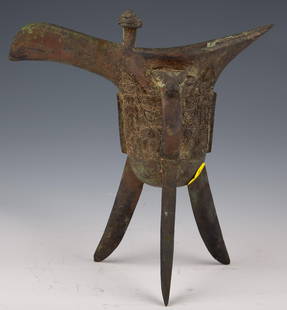 Shang Dynasty Libation Cup Jue on Three Legs: Shang Dynasty Libation Cup Jue on Three Legs" Introduction:
Step back in time to the illustrious era of the Shang Dynasty with this extraordinary Libation Cup Jue on Three Legs.