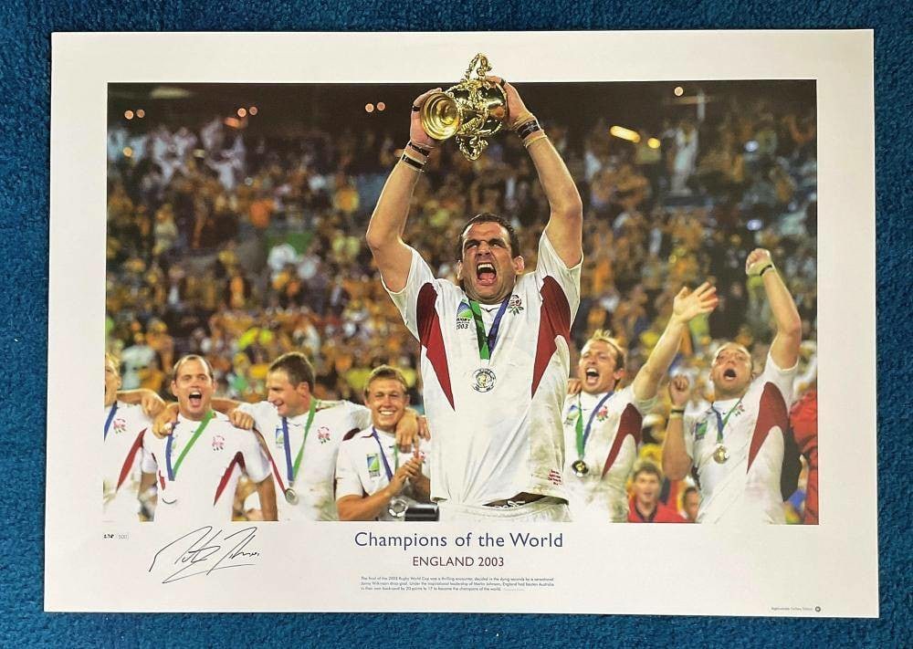 Martin Johnson signed 22x16 Champions of the World England 2003 Big Blue Tube print: Artist: Martin Johnson
Medium: Hand-signed print
Dimensions: 22 x 16 inches
Condition Report: Good condition; no visible damage.
Description: This limited edition print captures Martin