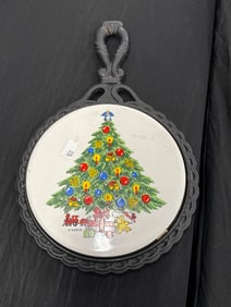 4 CHRISTMAS PLATES AND A PORCELAIN MIDSTATE CAST IRON KITCHEN TRIVET