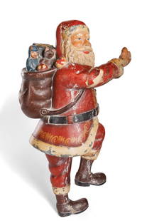 Carved Wood Santa Claus (early 20th century): Carved Wood Santa Claus (Early 20th century). Hand-carved and painted figure of Santa Claus carrying a sack full of toys, early twentieth century. 25 in. (63.5 cm.)