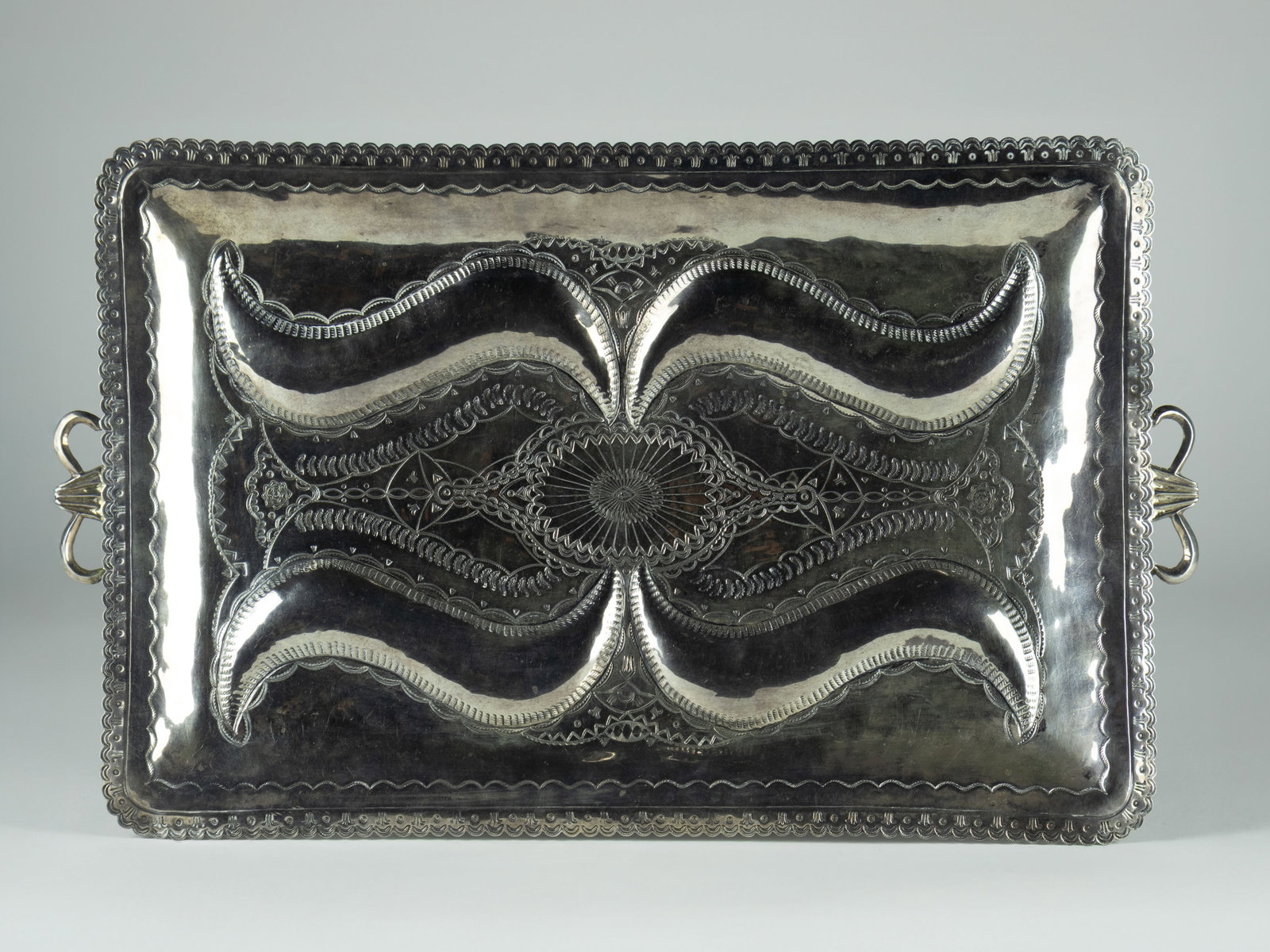 Ray Adakai, Navajo Stamped Sterling Silver Tray, c. 1990: Ray Adakai Navajo (Diné), b.1965 Navajo Stamped Sterling Silver Tray, c. 1990 sterling silver stamped: Sterling Ray Adakai 1,857 g 1 1/2 x 19 1/2 x 11 3/4 in. Provenance: From a Private