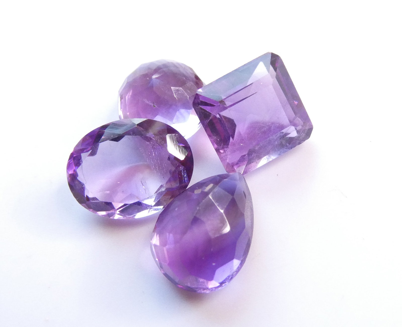 Brazil natural untreated amethysts lot, 15.80 ct total weight: A fine collection of natural amethysts from Brazil, with a combined weight of 15.80 carats, showcasing a captivating mix of purple to bluish-purple hues. This mixed lot includes multiple faceted stone