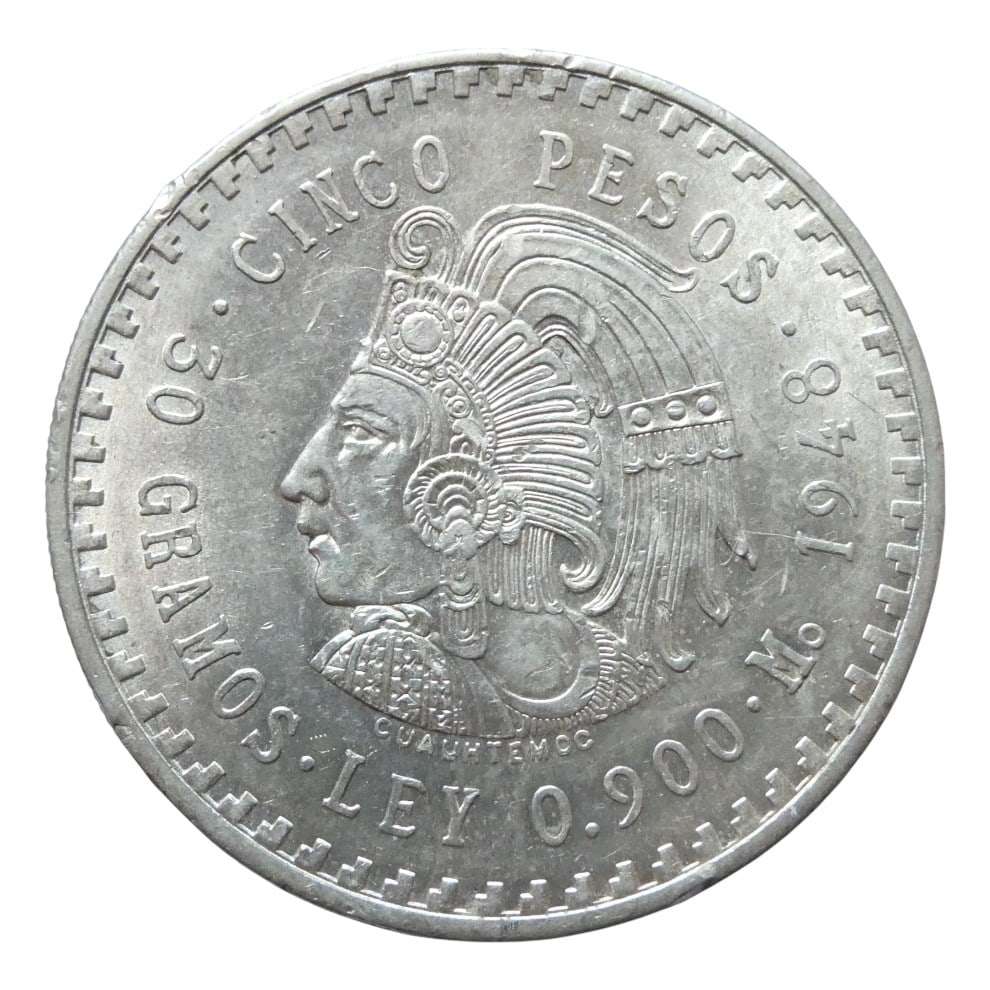 1948 Mexico 5 Pesos Silver Coin, Cuauhtemoc, .900 Fine, 30g: This 5 Pesos silver coin from Mexico was struck in 1948 and features a powerful left-facing bust of Cuauhtemoc, the last Aztec emperor, adorned in traditional feathered regalia. The obverse is surroun