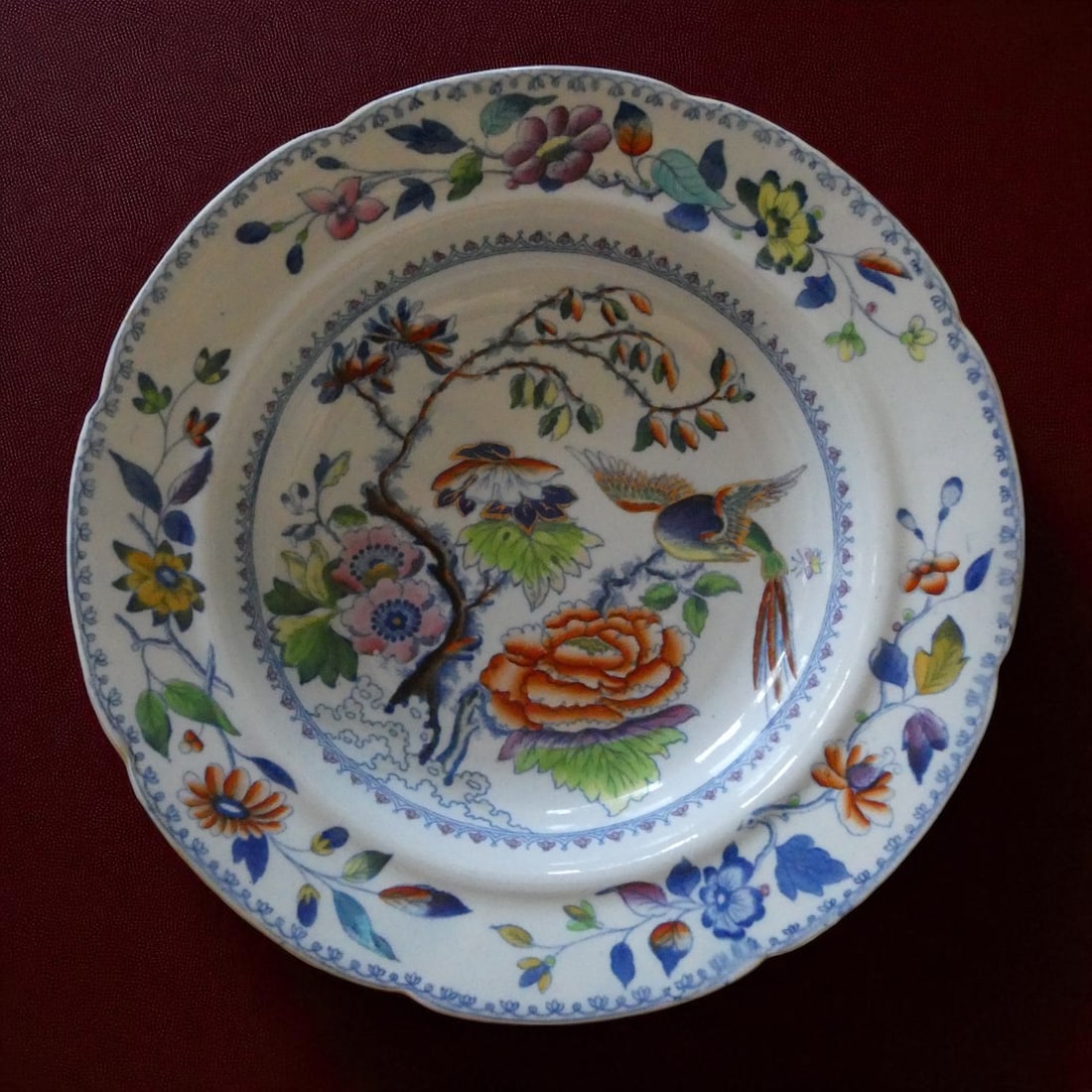 Early 19th Century Davenport Bone China Plate with Oriental Bird and Floral Motif: This finely potted and vividly decorated bone china plate was produced by the renowned English factory Davenport, active in Longport, Staffordshire, during the late 18th and 19th centuries. Measuring