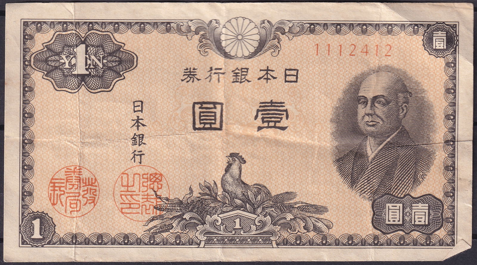 Japan 1946 One Yen Banknote – Rooster & Ninomiya Sontoku – P-85 – SN 1112412: Issued in 1946 by the Bank of Japan, this 1 Yen note (Pick 85) is part of the first post-war series. The obverse features a detailed portrait of Ninomiya Sontoku, the renowned 19th-century agricultura