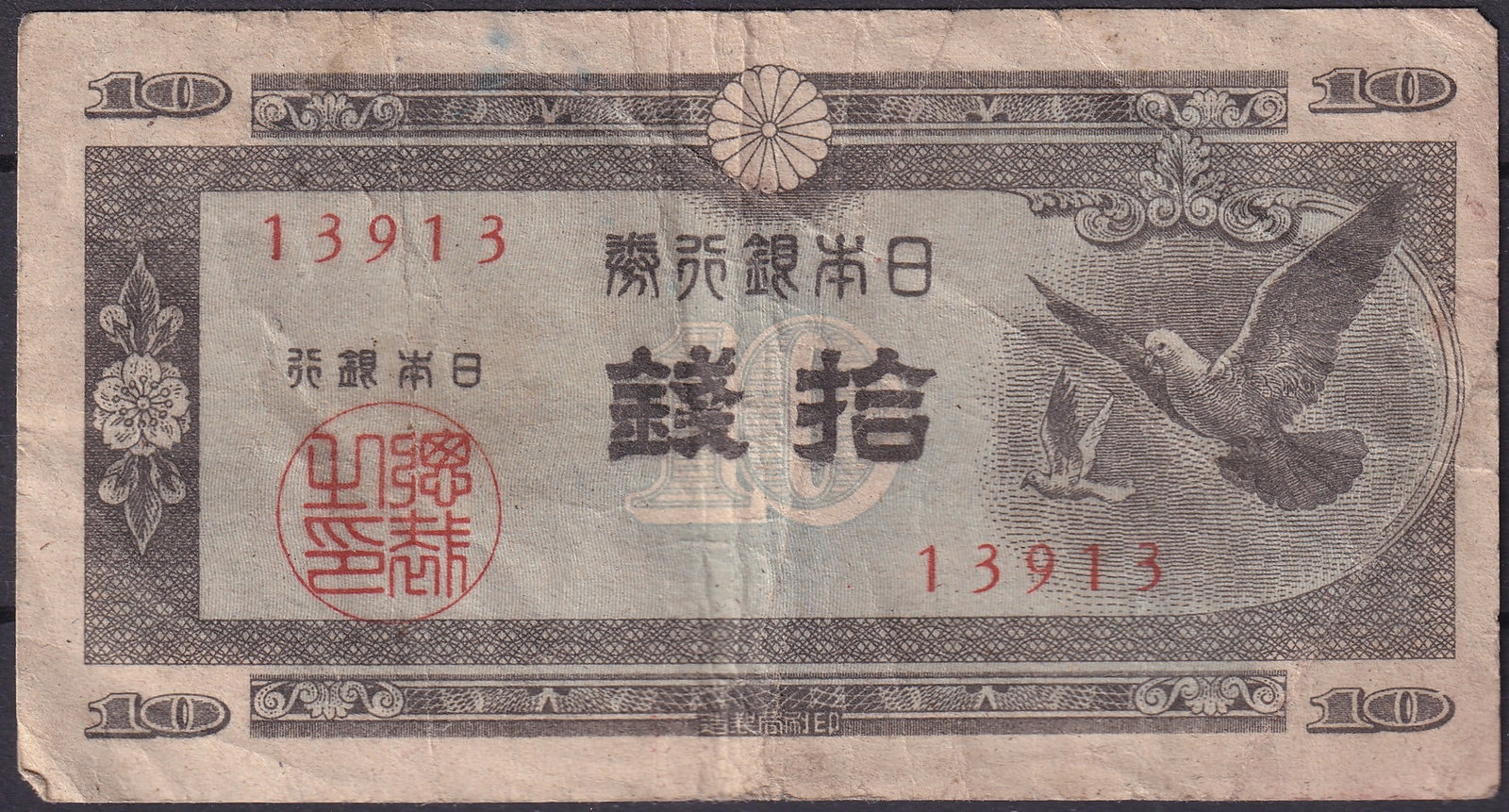 Japan 10 Sen Banknote, Flying Doves, 1944, Pick 700: Issued in 1944 during the final years of World War II, this Japanese 10 Sen banknote (Pick 700) represents a fascinating historical artifact from the Showa era. The obverse features a detailed vignett