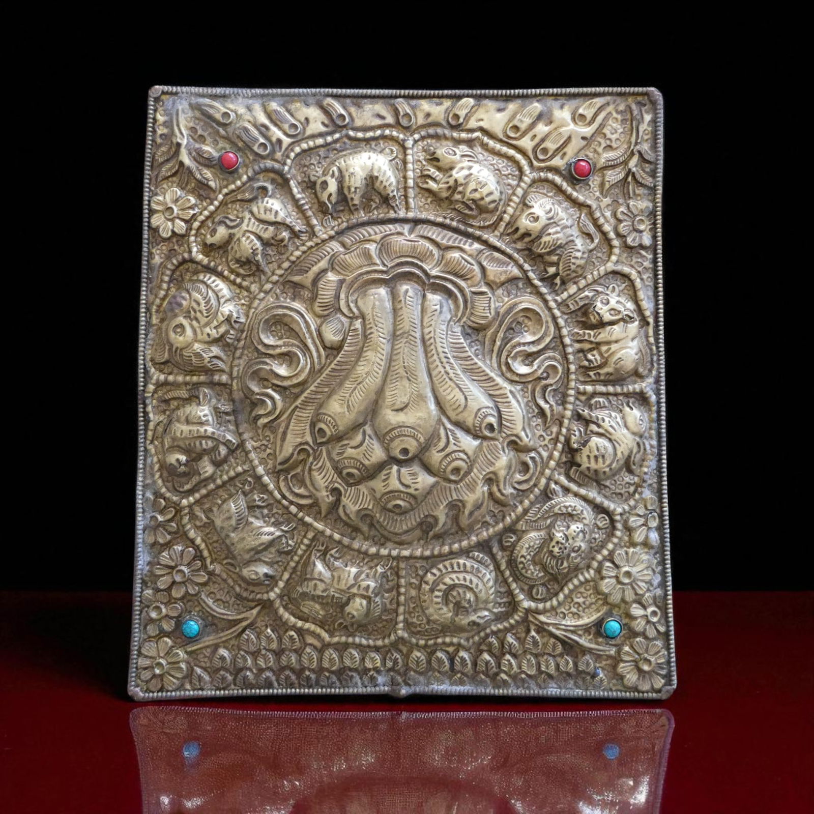 Nepalese Repoussé Brass Plaque with Zodiac Motifs, mid–late 20th c.: A repoussé brass plaque from Nepal, dating to the mid to late 20th century, executed in traditional Himalayan style with religious and decorative symbolism. The rectangular plaque measures 22 by 19 c
