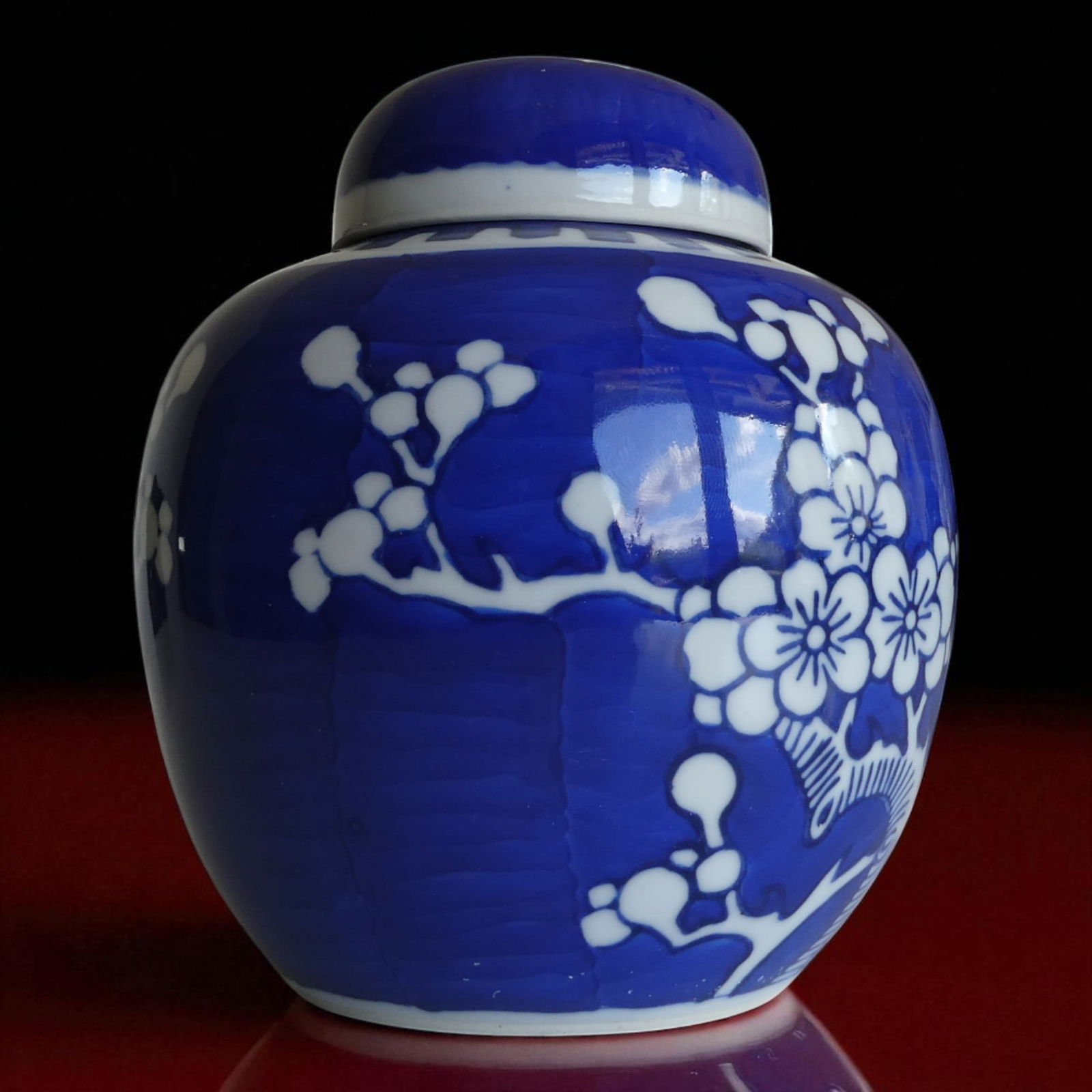 Chinese Export Porcelain Ginger Jar with Prunus Blossom Motif, Qing Style: This Chinese export porcelain ginger jar exemplifies the enduring aesthetic of Qing dynasty decorative arts, specifically drawing on late 19th to early 20th-century stylistic influences. Measuring 15