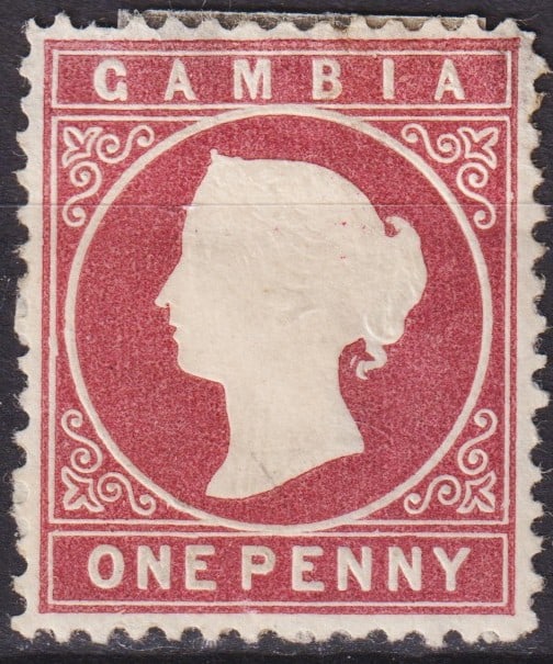 Gambia 1887 Queen Victoria 1d Light Carmine, Scott GM 13c: This rare Gambia 1887 Queen Victoria issue, denominated 1 penny in light carmine, features the iconic silhouette portrait of Queen Victoria set within an ornamental circular frame. Printed by De La Ru