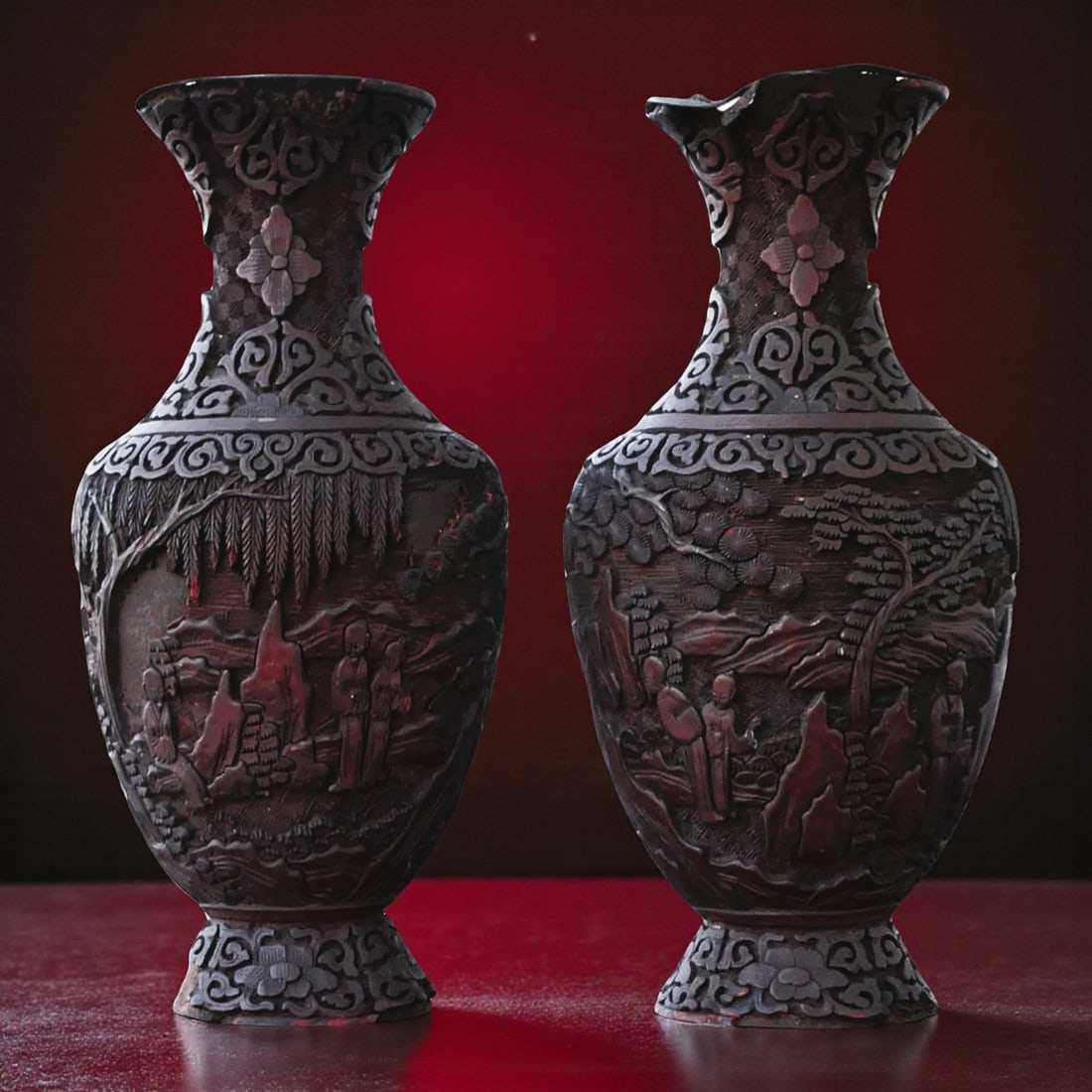 Pair of Ming Dynasty Cinnabar Lacquer Vases with Landscape Motifs 17th Century: This exquisite pair of cinnabar lacquer vases dates from the Ming Dynasty, likely from the 17th century. Each vase stands approximately 26 cm high and is finely carved in deep relief with intricate la