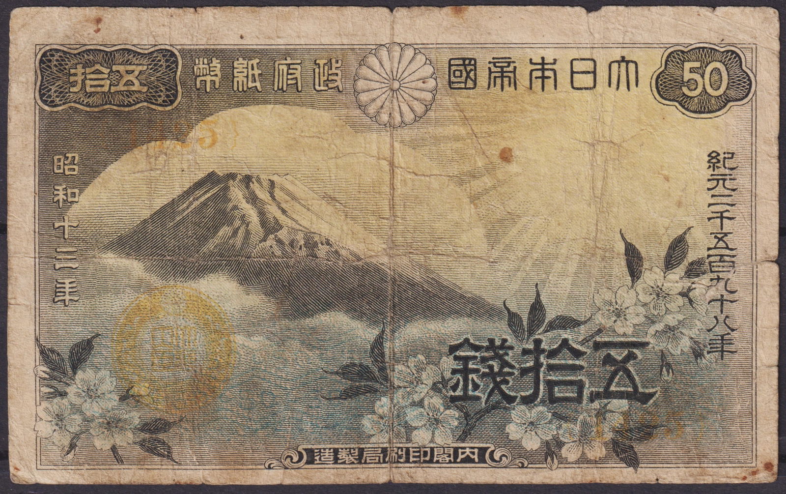 Japan 50 Sen Banknote, Mount Fuji and Cherry Blossoms, 1938 Showa Era: This is an original Japanese 50 Sen banknote issued in 1938 during the Showa era, a period of rapid modernization and increasing militarization leading up to World War II. The front side of the note d